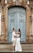 a man and woman standing in front of a blue door