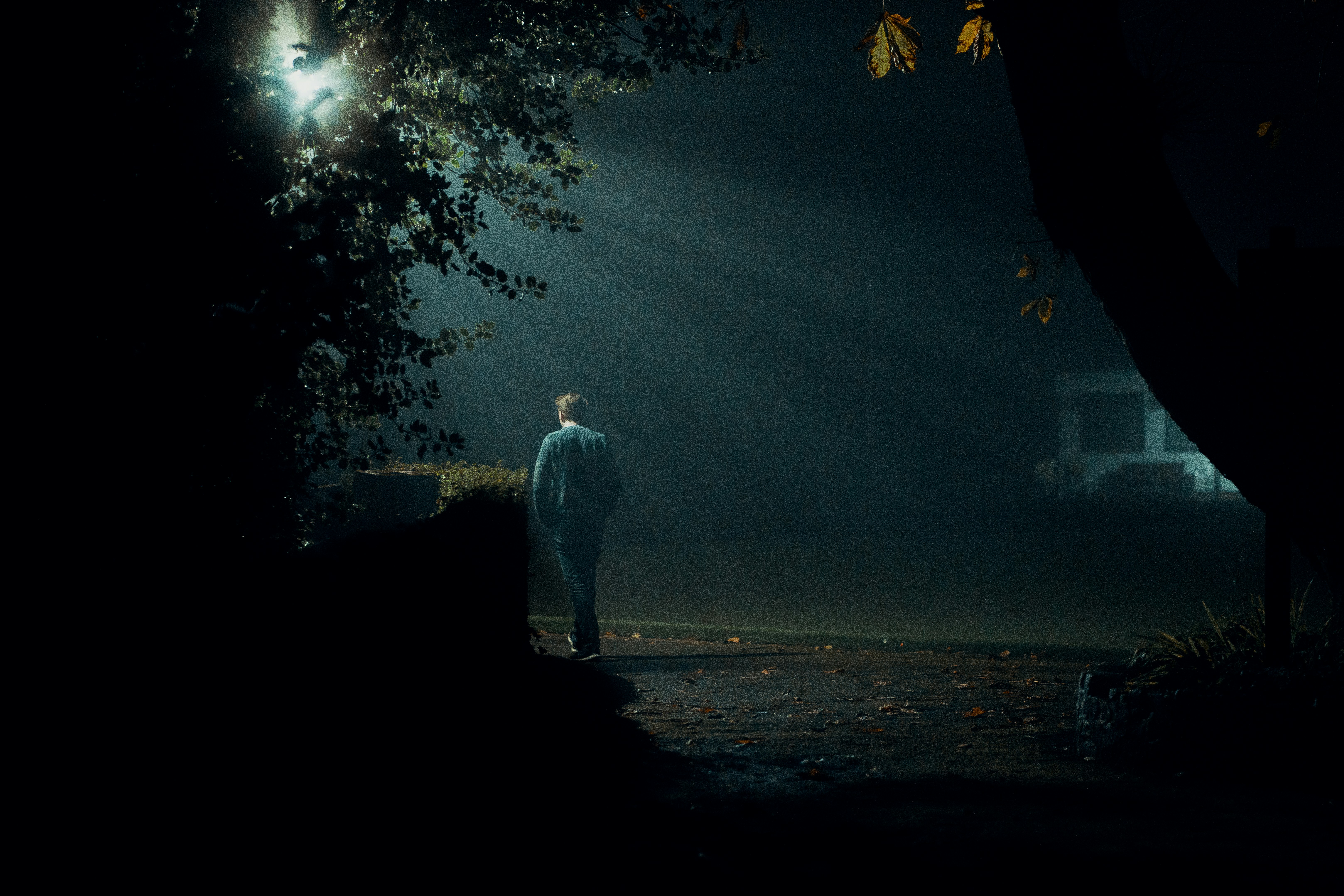 a man standing in the dark under a street light