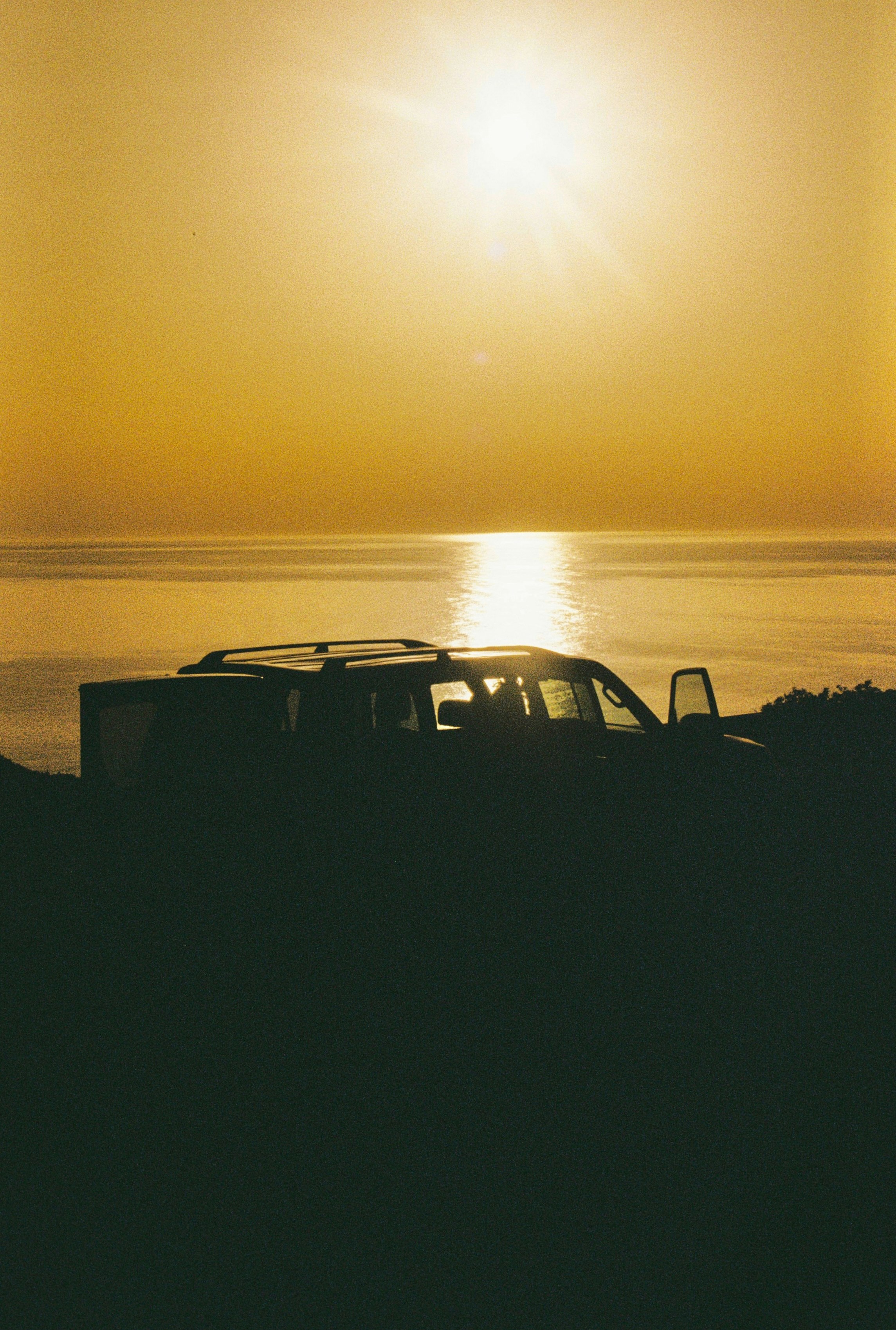 a car parked on the side of a road near the ocean