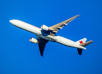 a canadian airplane flying in a blue sky