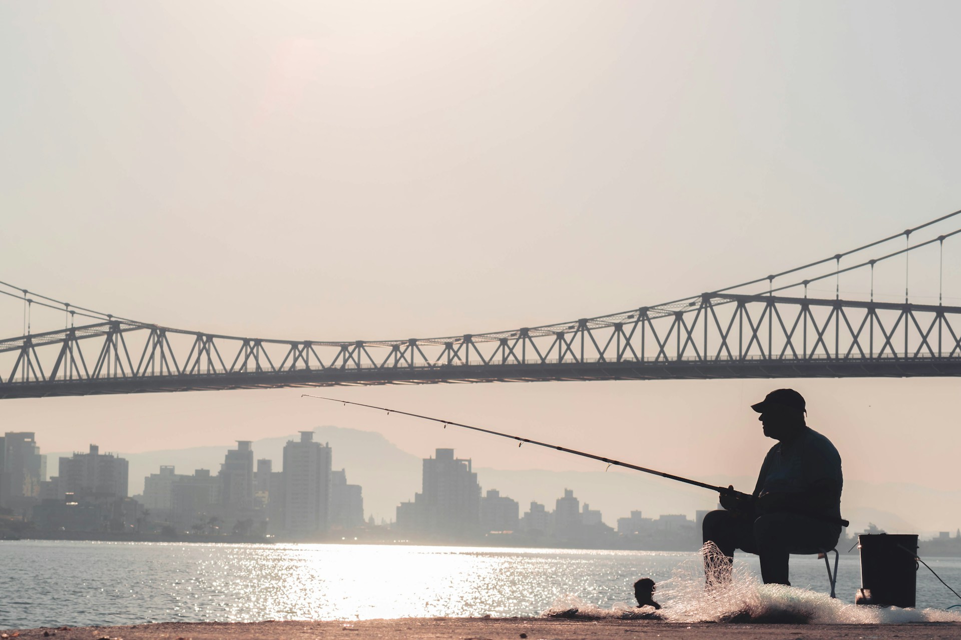 a man sitting on a bench while fishing