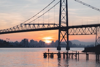 a bridge over a body of water with buildings in the background