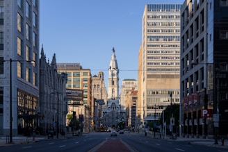 a city street with tall buildings and a clock tower