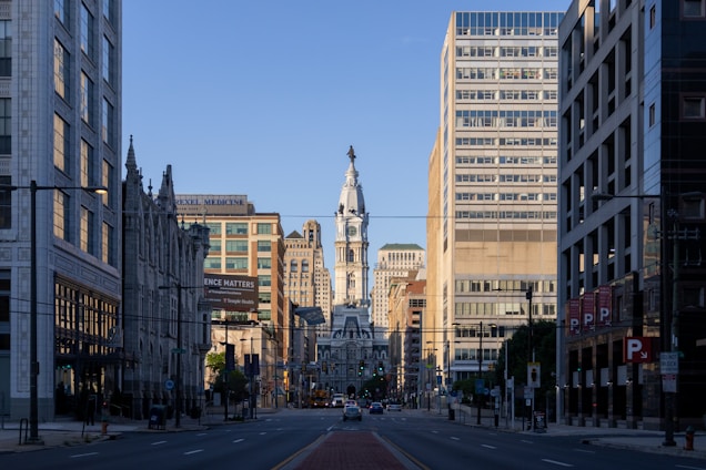 a city street with tall buildings and a clock tower