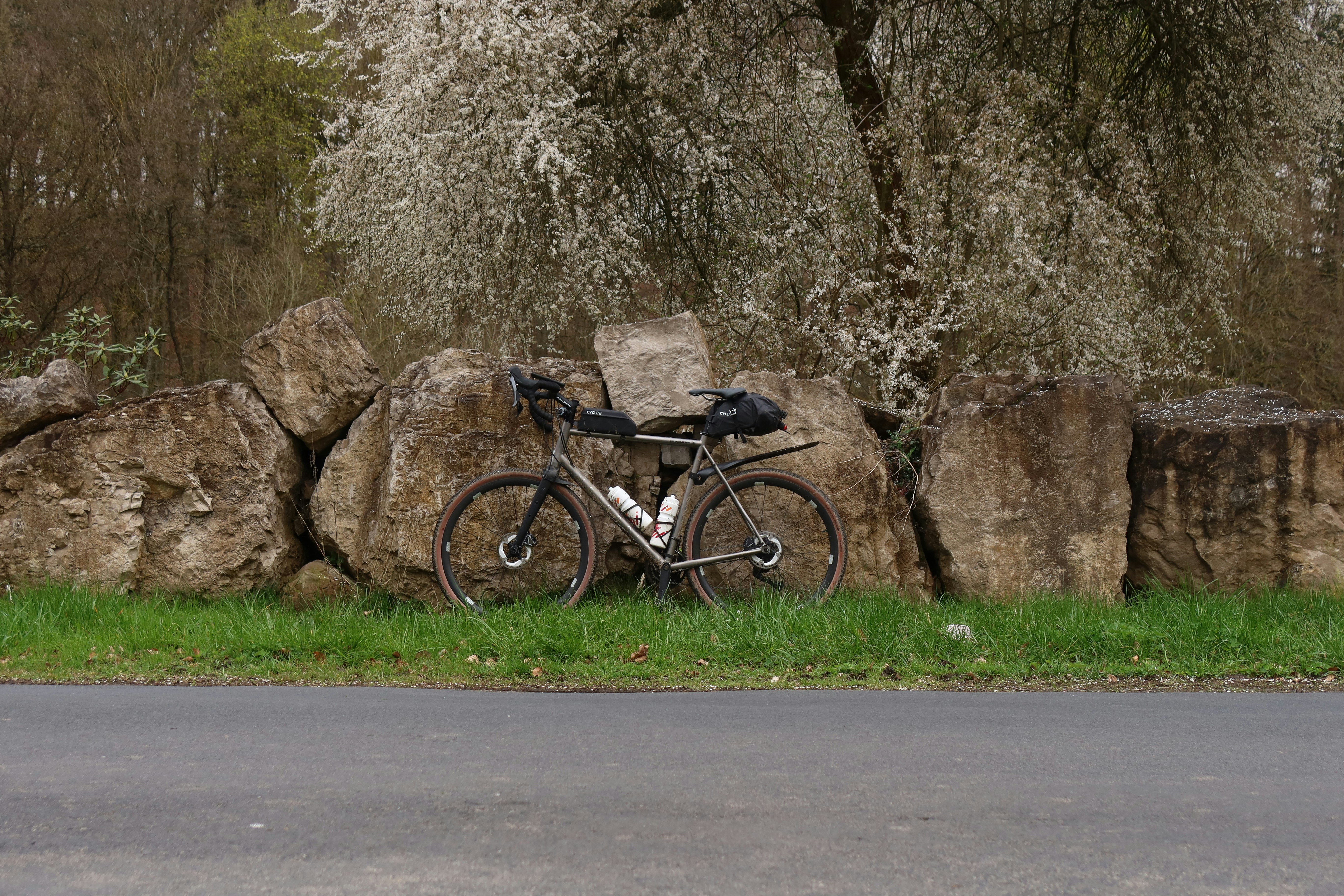 a bicycle parked next to a rock wall