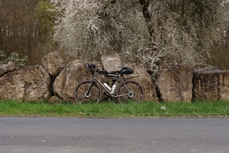 a bicycle parked next to a rock wall
