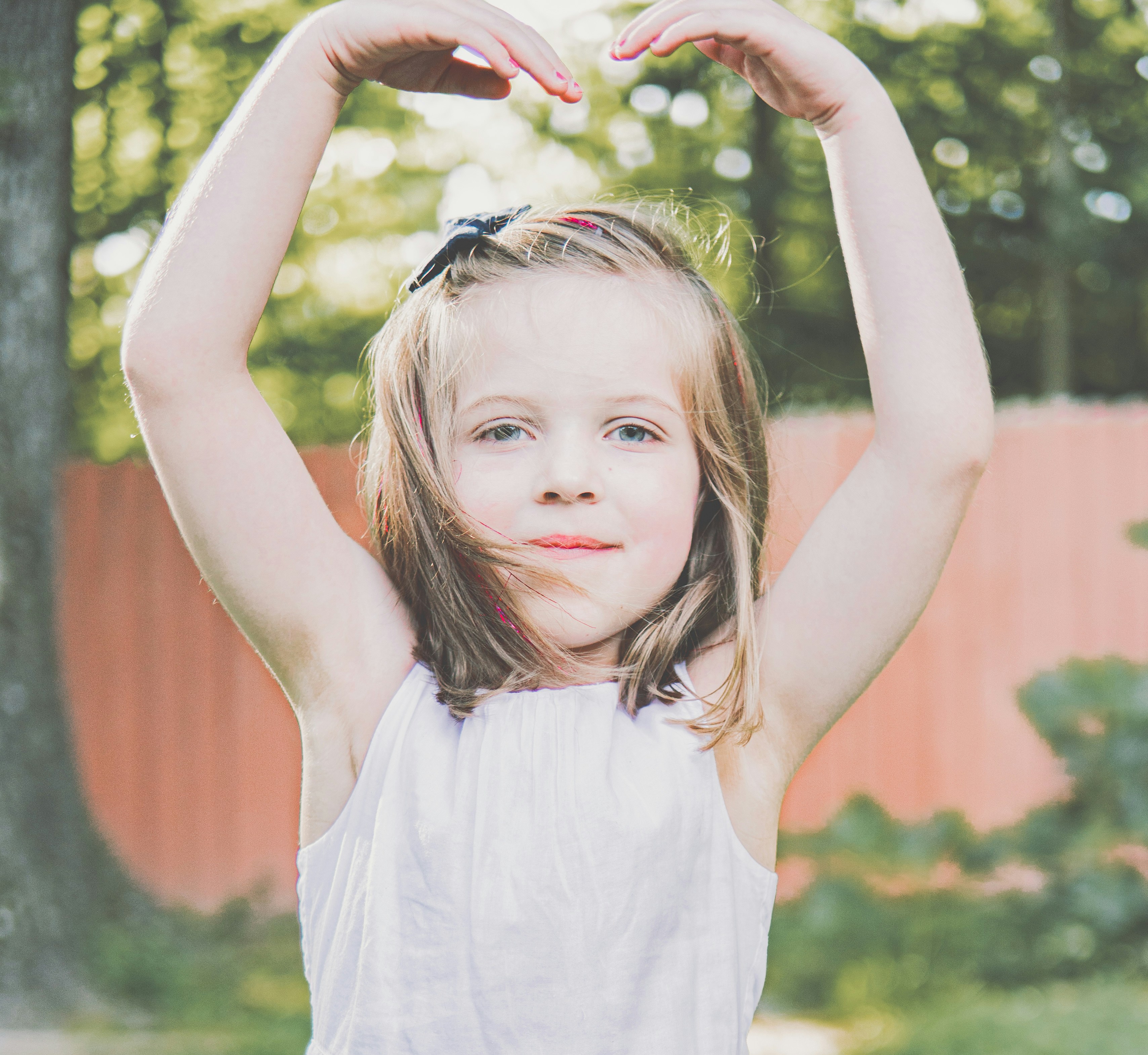 A little girl holding her hands up in the air photo – Free Symbol Image ...