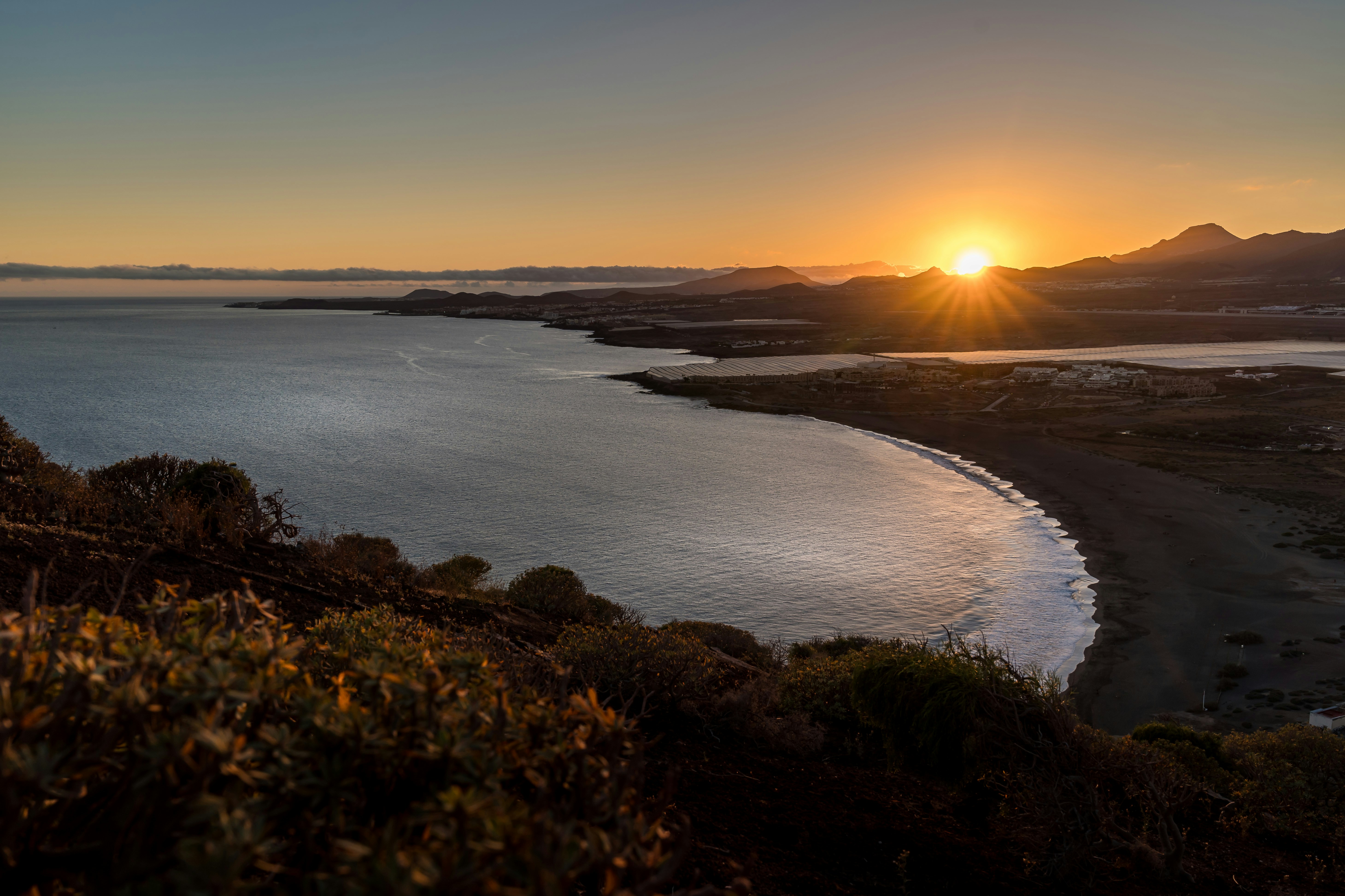 the sun is setting over a body of water