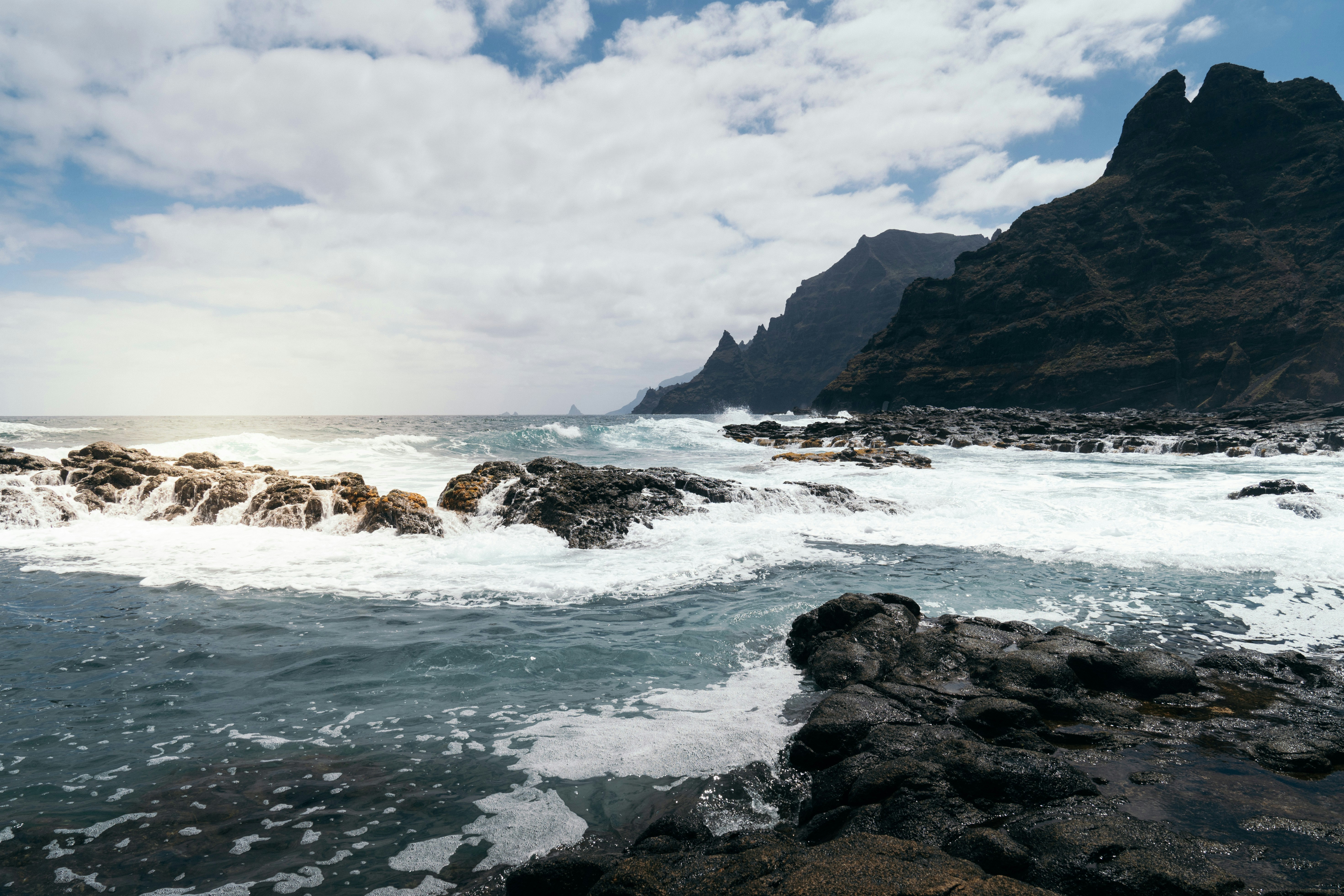 a rocky beach with waves crashing against the rocks