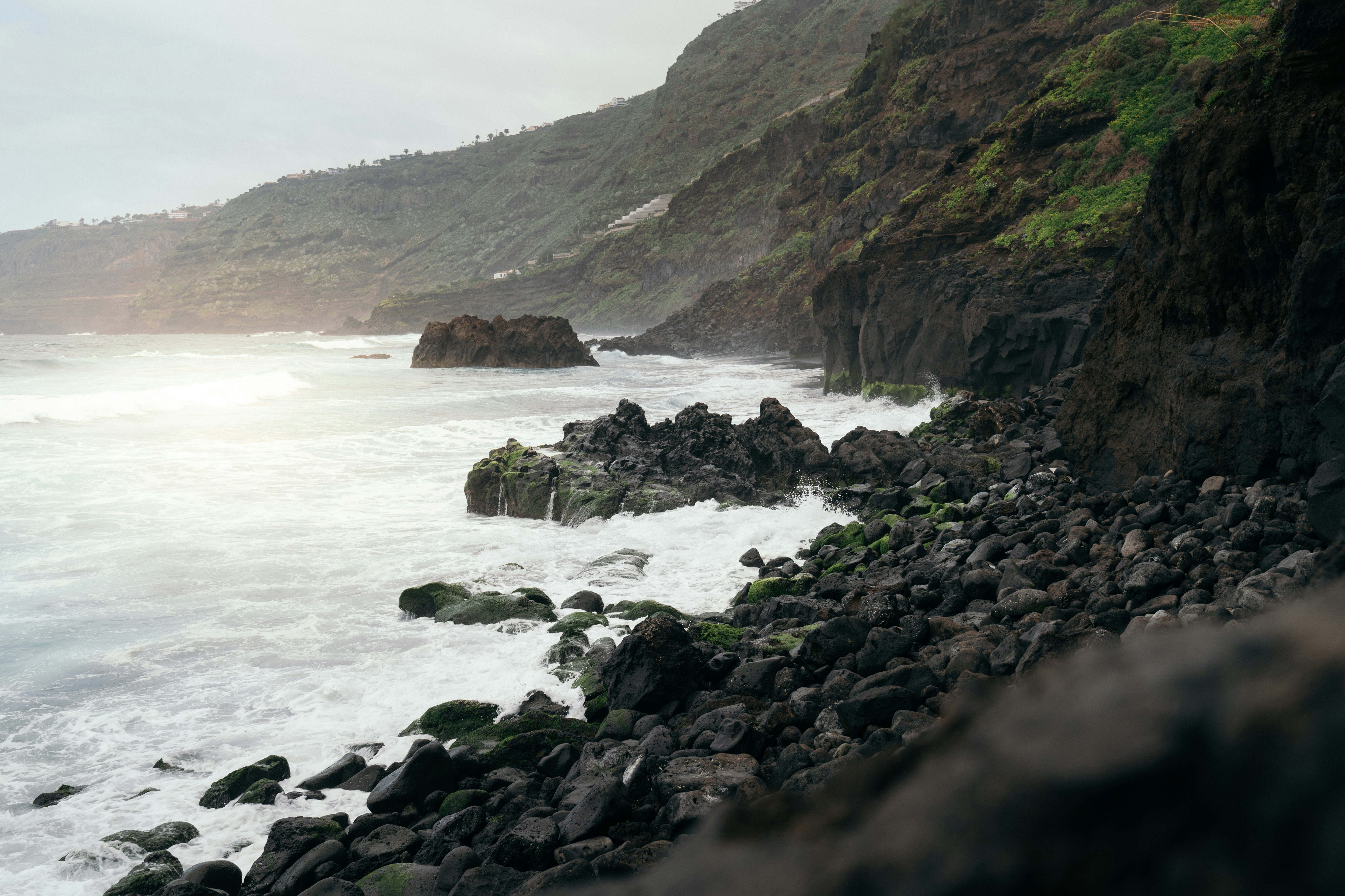 a rocky shore line with waves crashing against the rocks