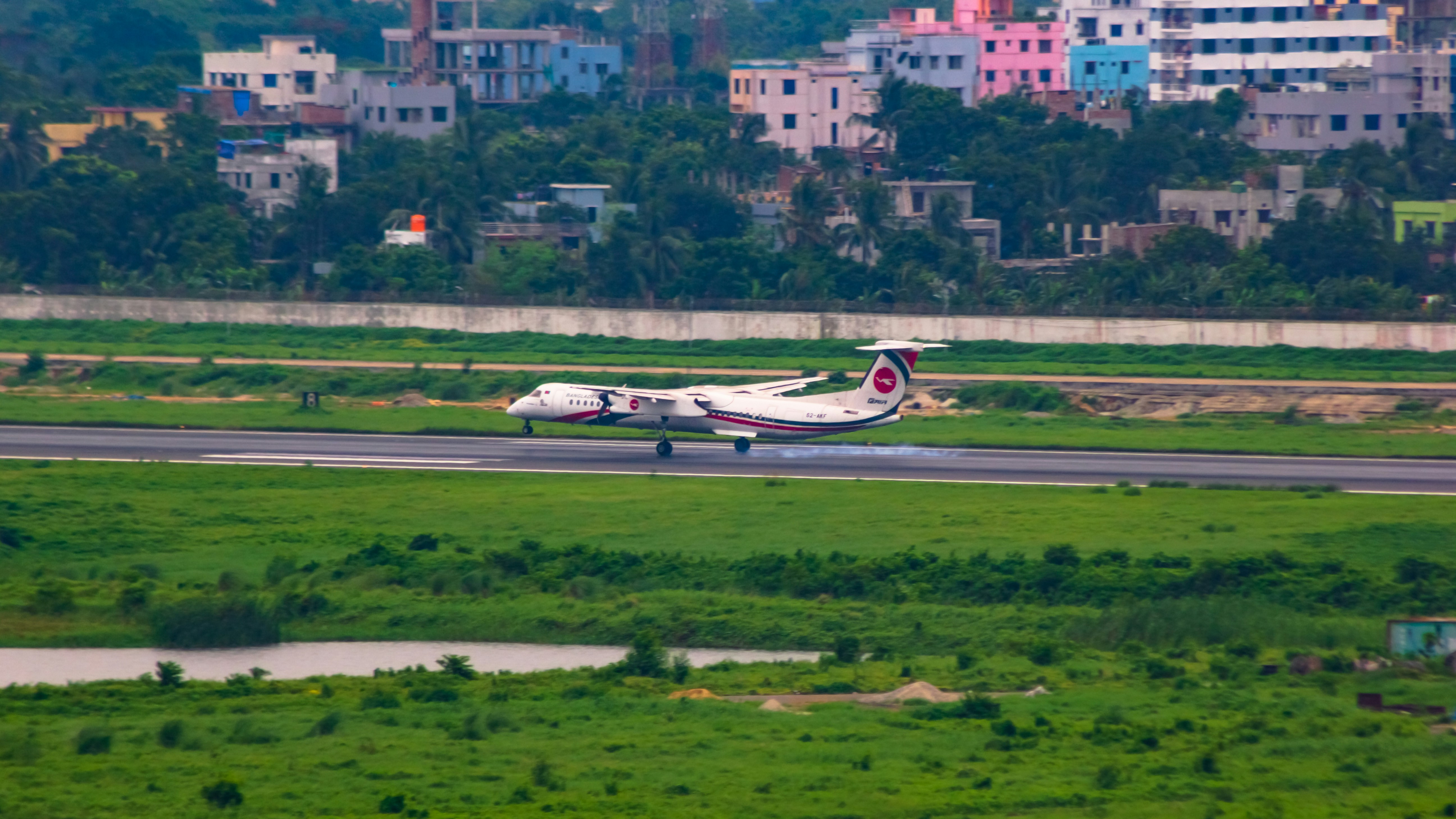 Air India plane taking off from a runway at dawn, with a bustling airport in the background. The plane has the Air India livery clearly visible.