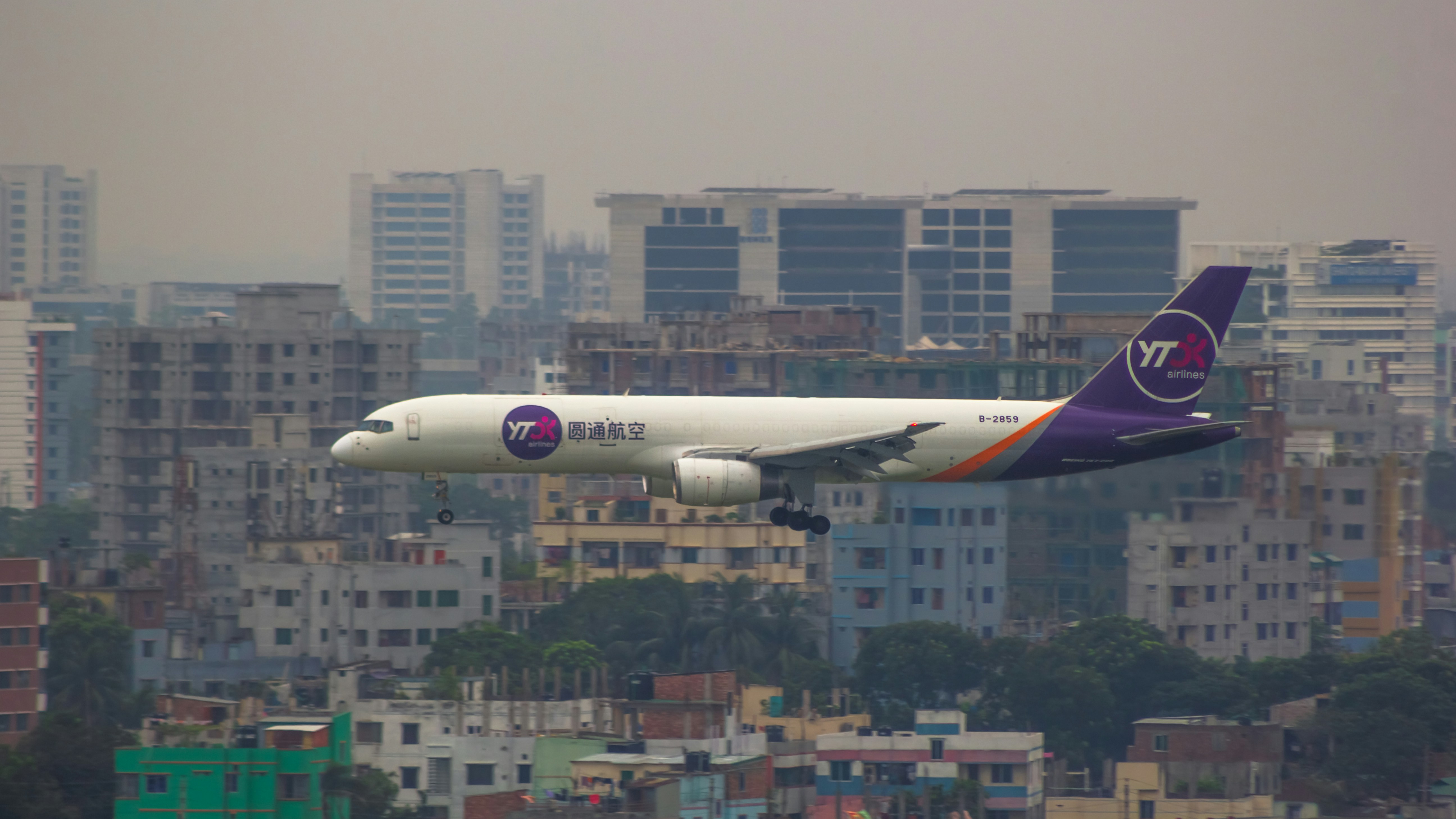 a large passenger jet flying over a city, YTO Cargo Airlines,