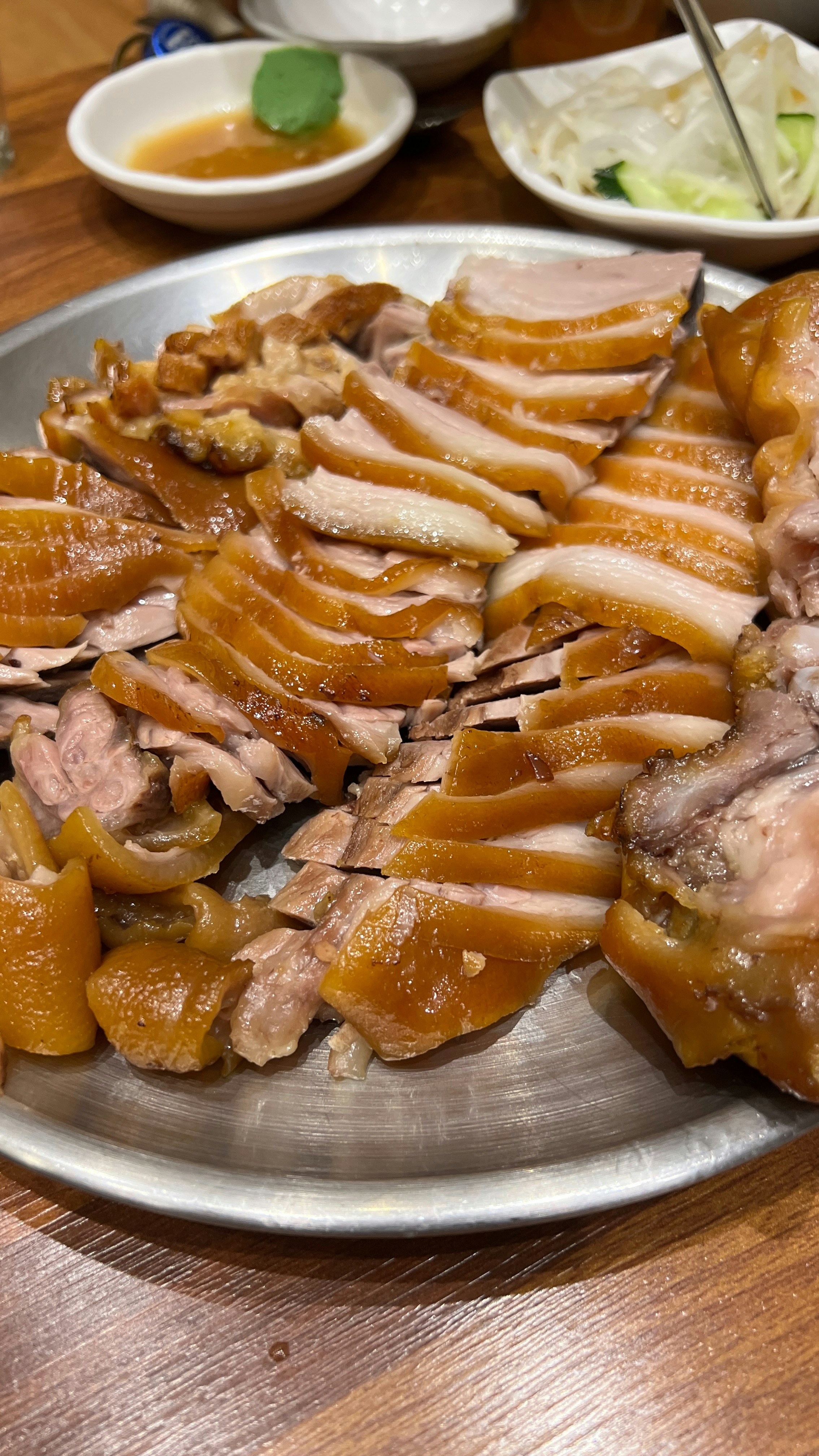 Traditional Korean braised pork dish jokbal with side dishes and dipping sauce