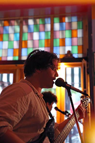 a man playing a guitar and singing into a microphone