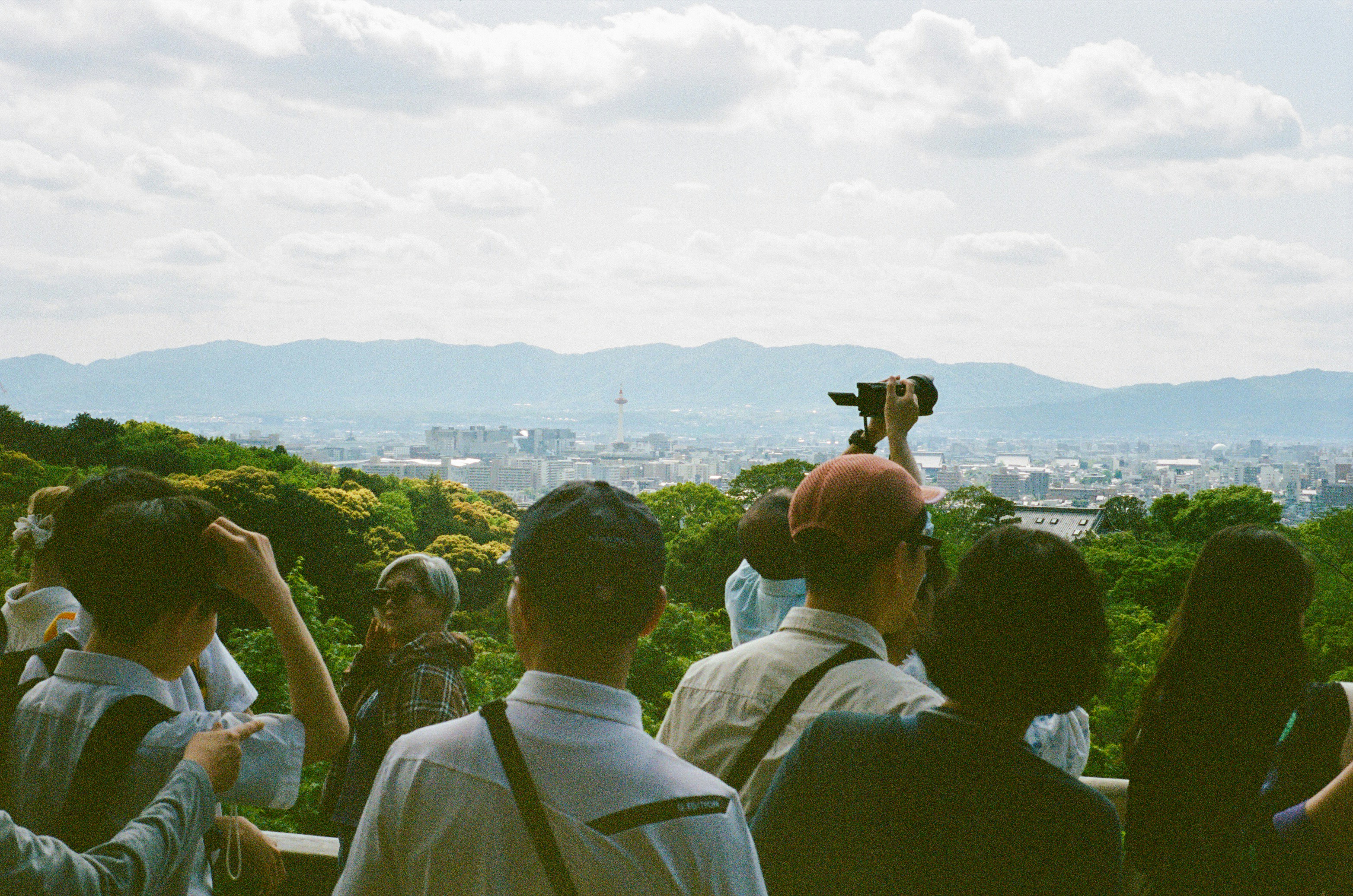 A group of people standing on top of a lush green hillside photo – Free ...