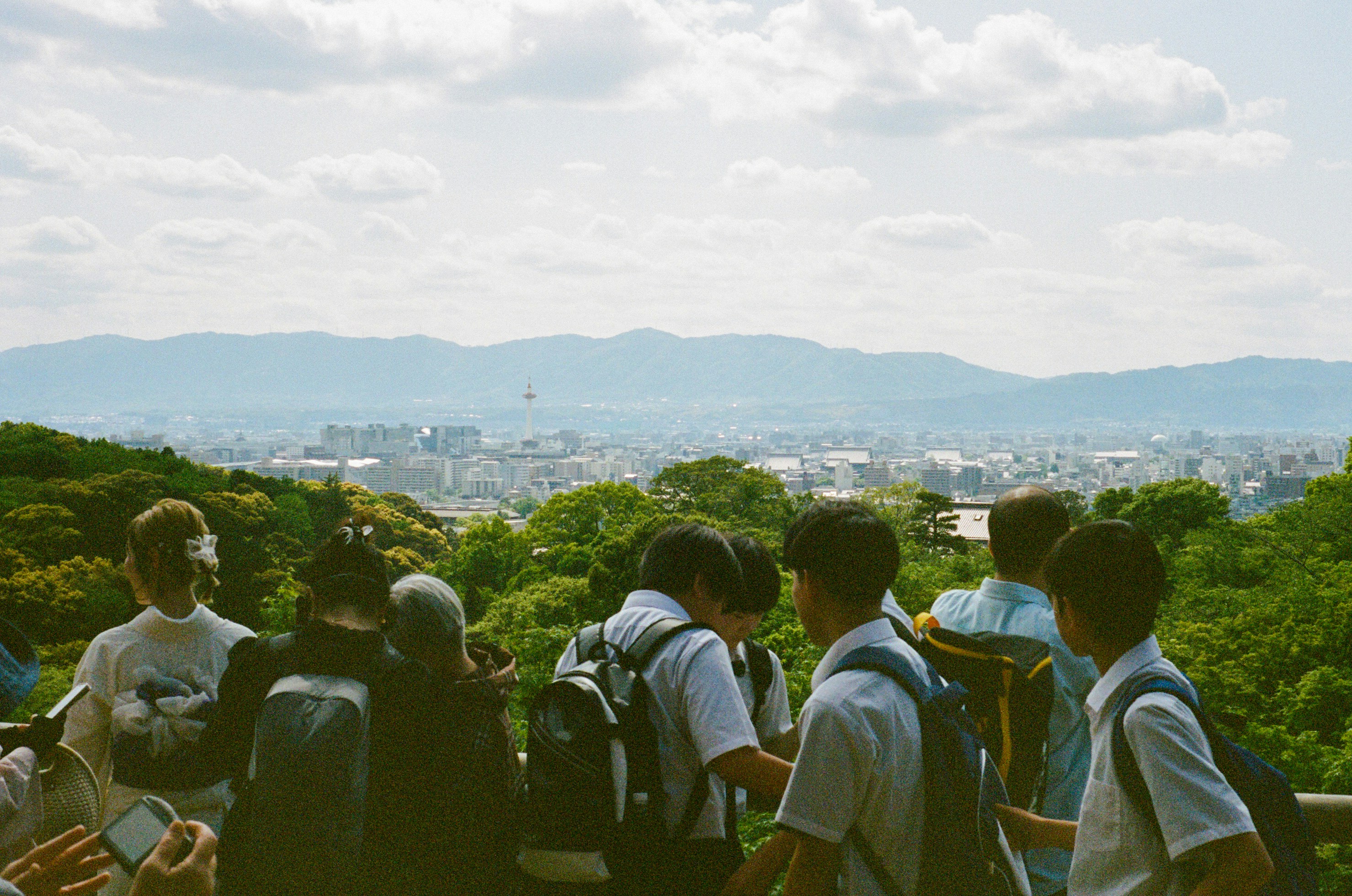 a group of people standing on top of a lush green hillside