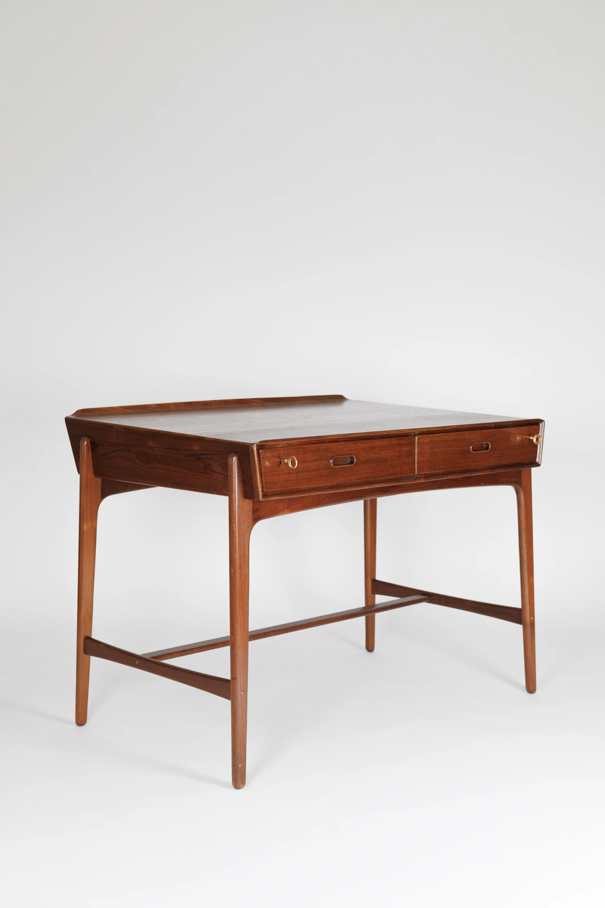 Dark mahogany executive table with awards and trophies in low light.