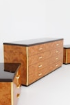 a set of three wooden dressers with black marble top