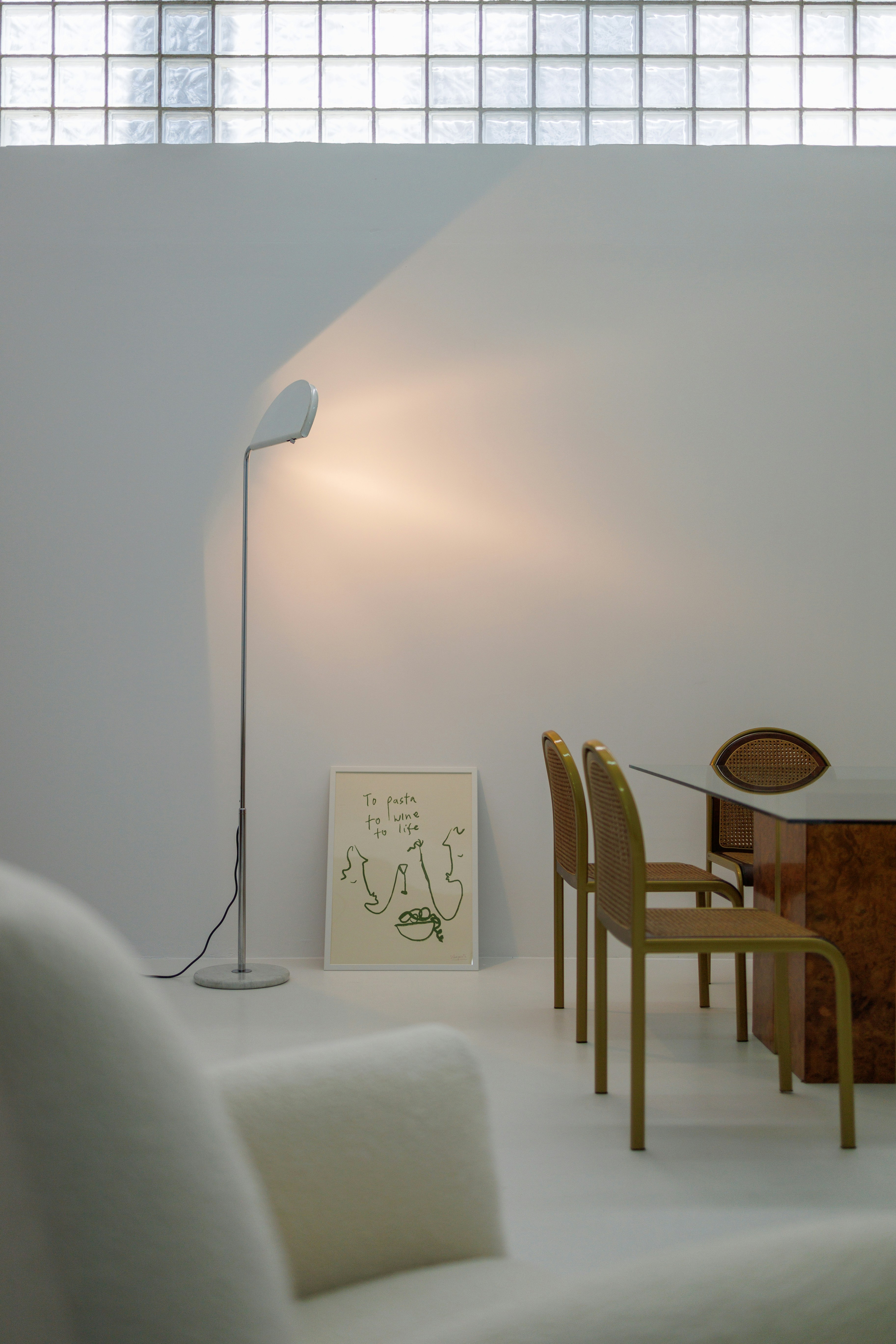 a living room with a white couch a table and a lamp