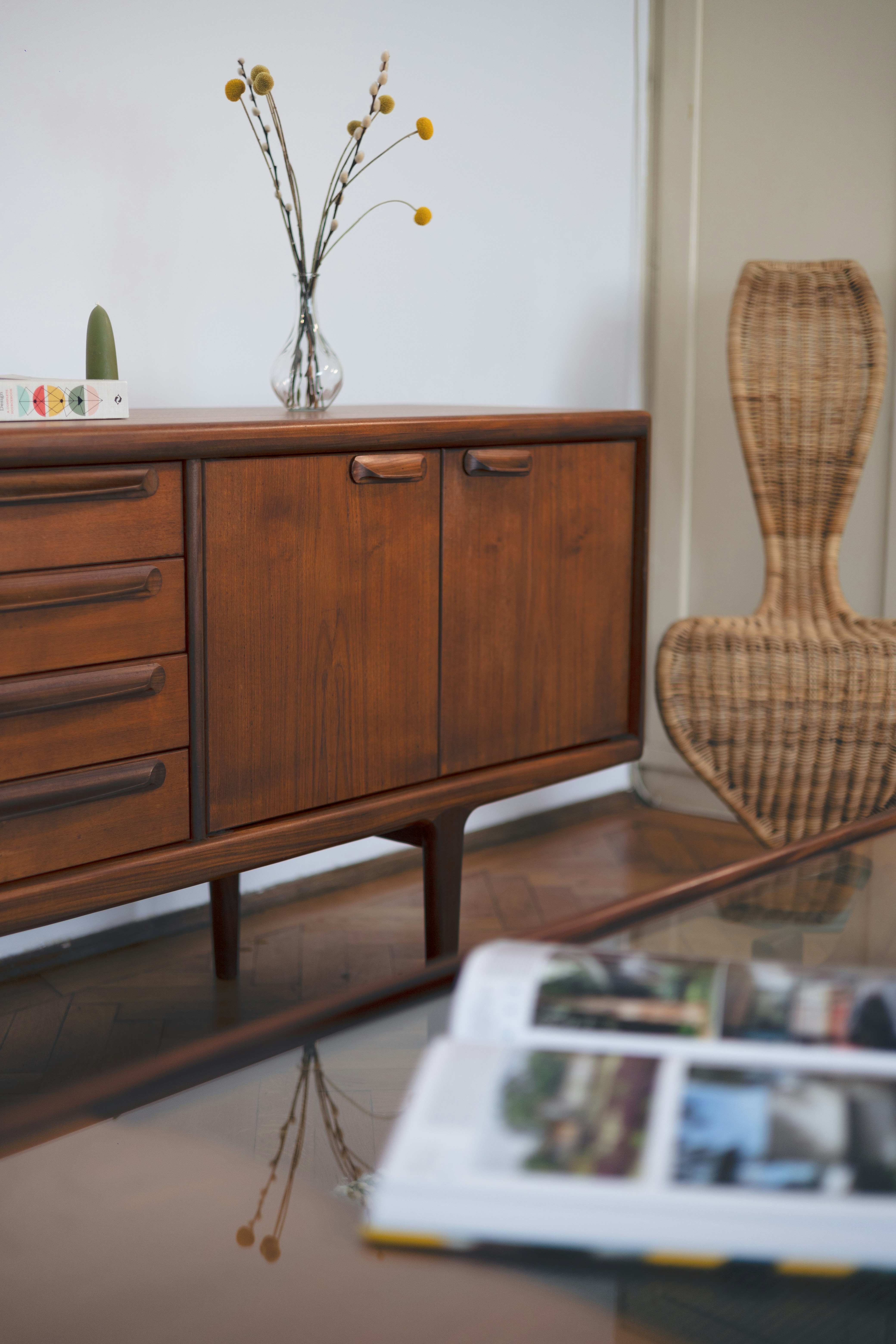 a wooden cabinet with a vase of flowers on top of it