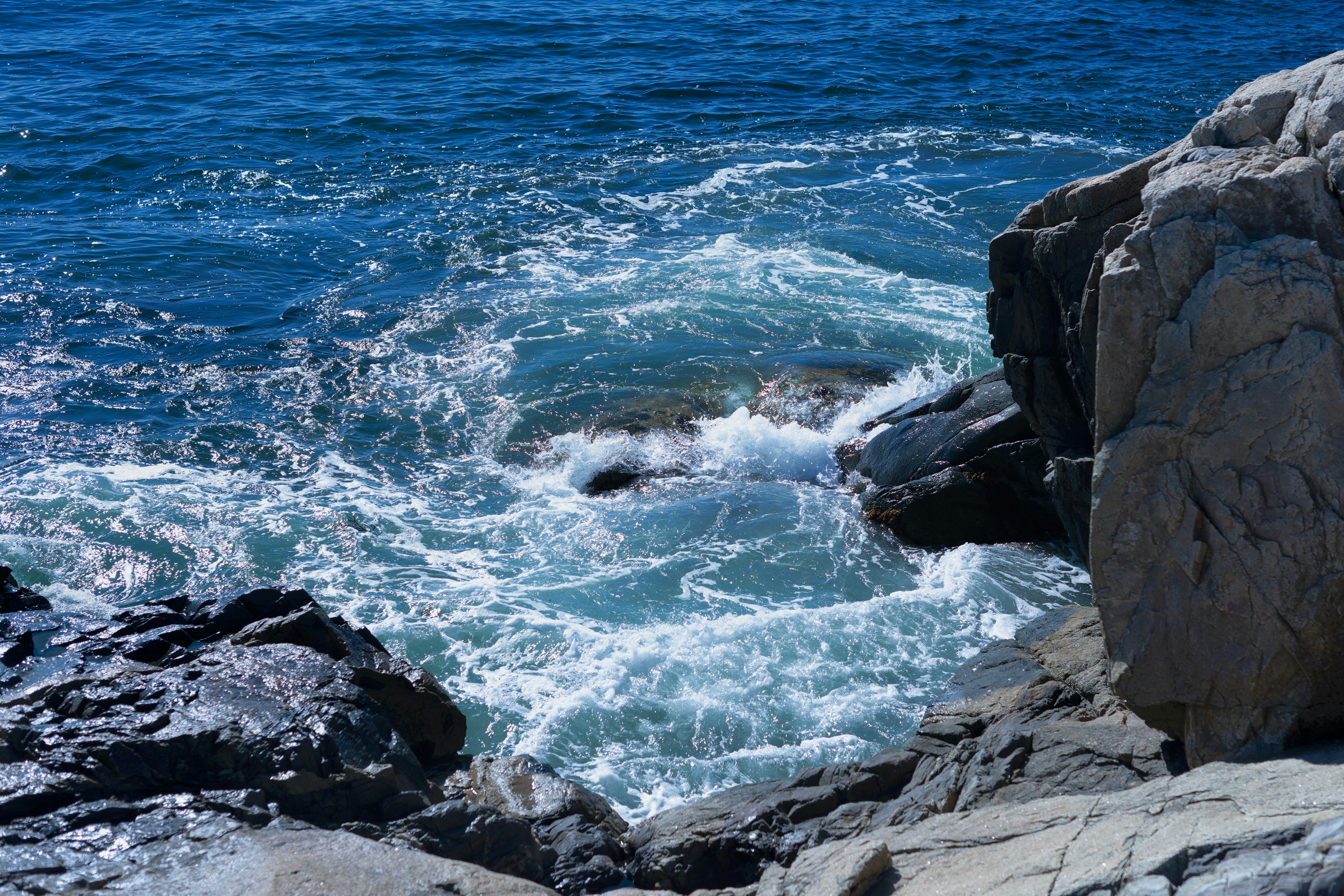 a body of water surrounded by rocks and water, Natural whirlpool forms in a rocky grotto along the Maine coast.
