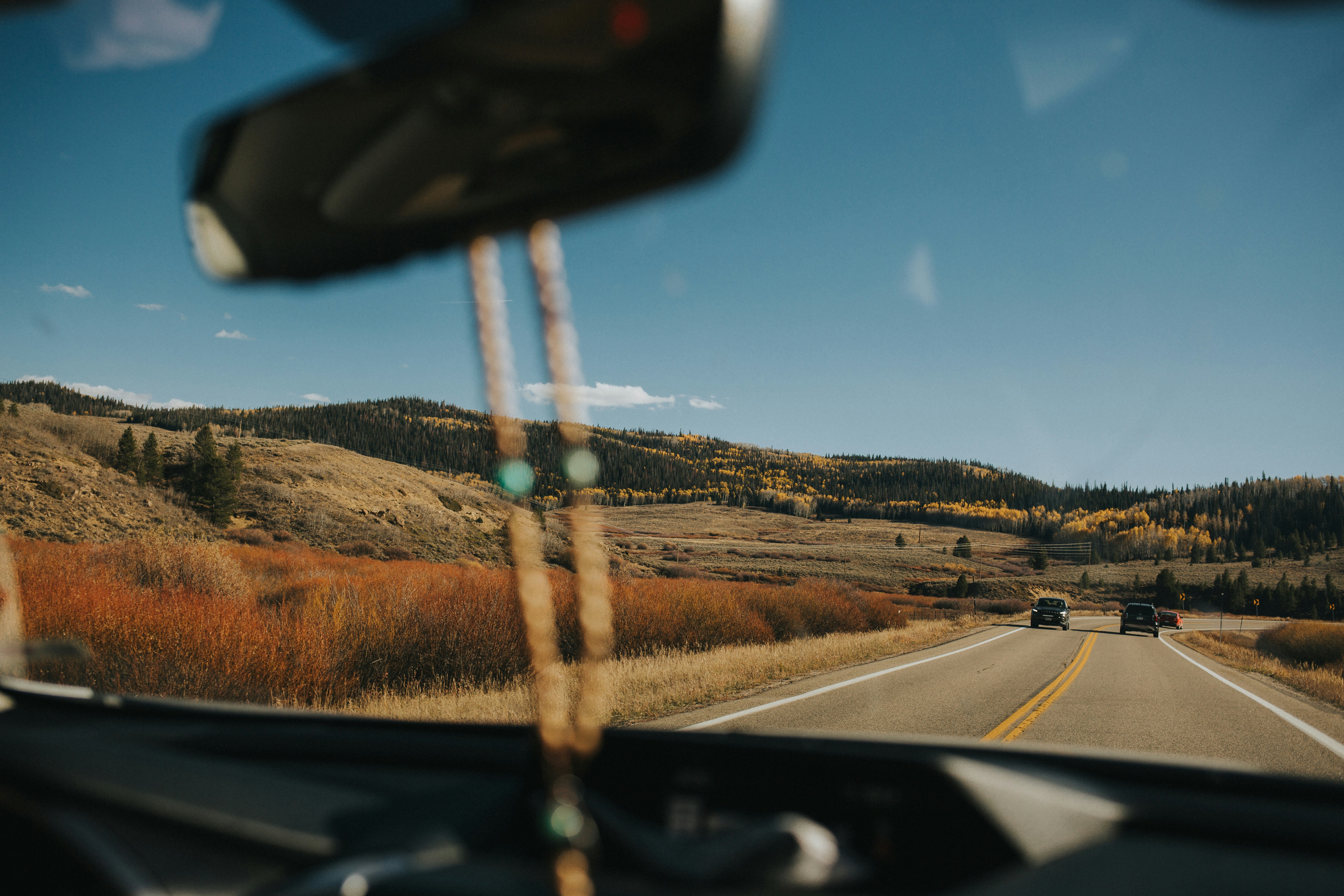 Una vista desde el interior de un vehículo de una carretera con una montaña al fondo