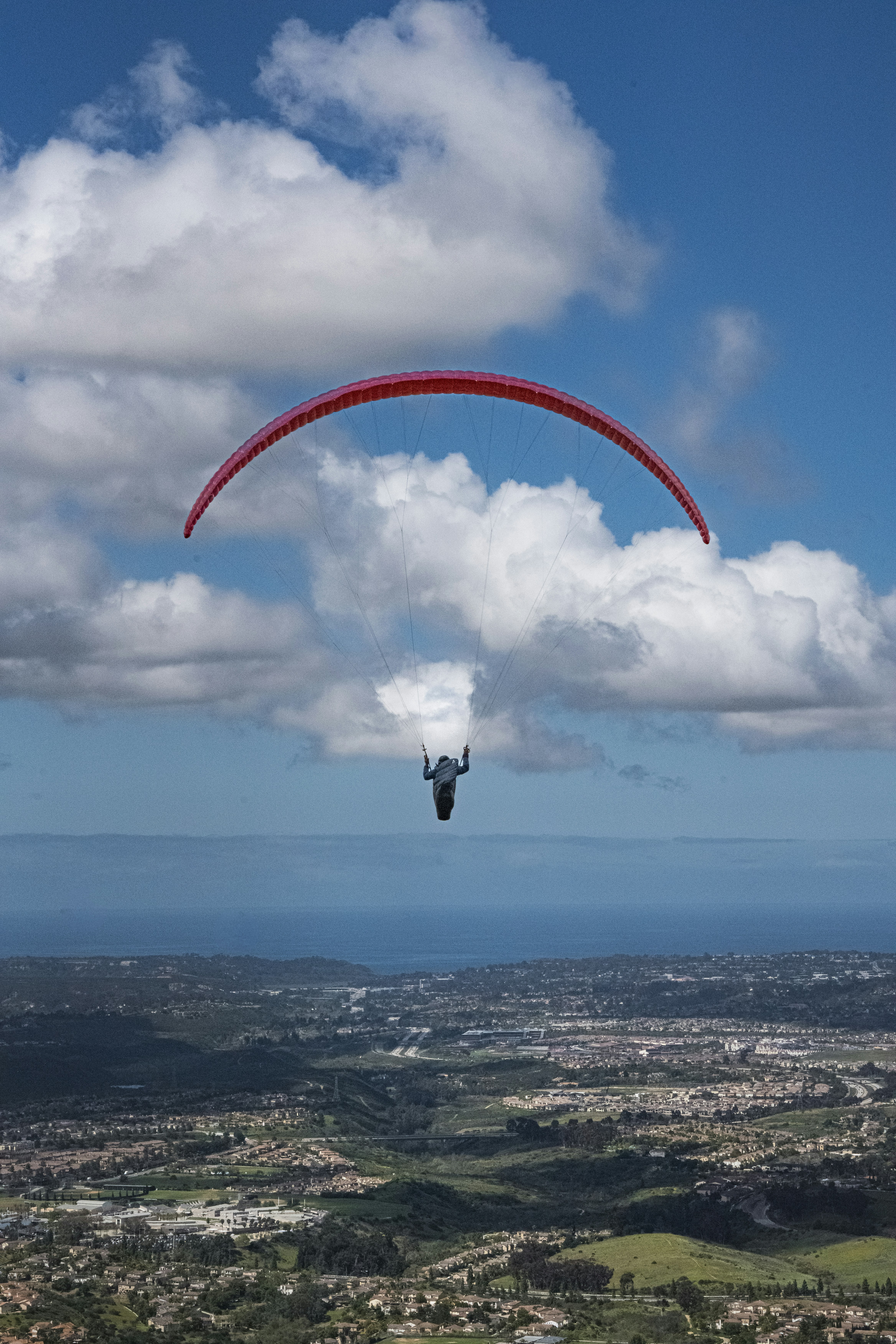 a person is parasailing in the sky above a city