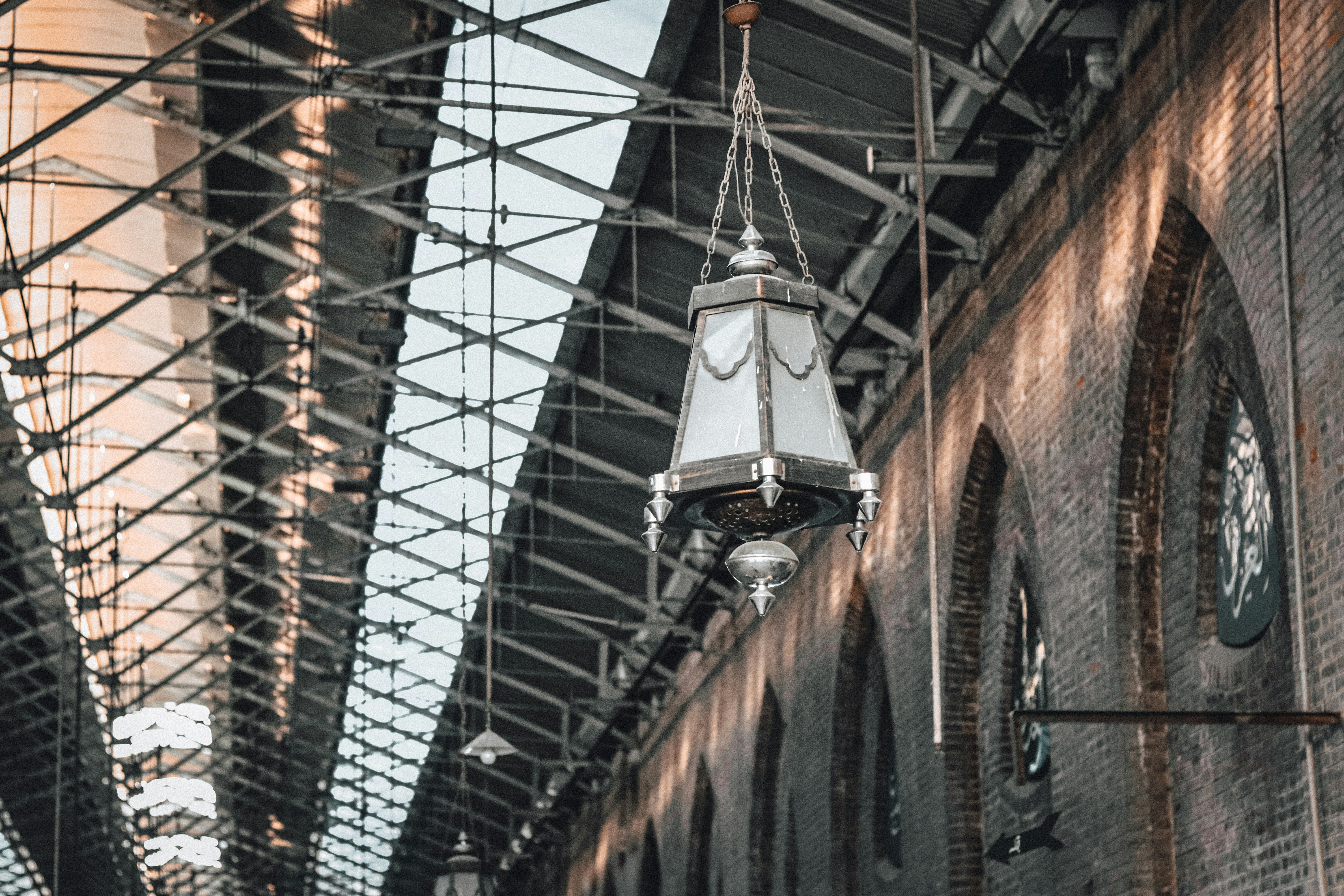 a clock hanging from the ceiling of a train station