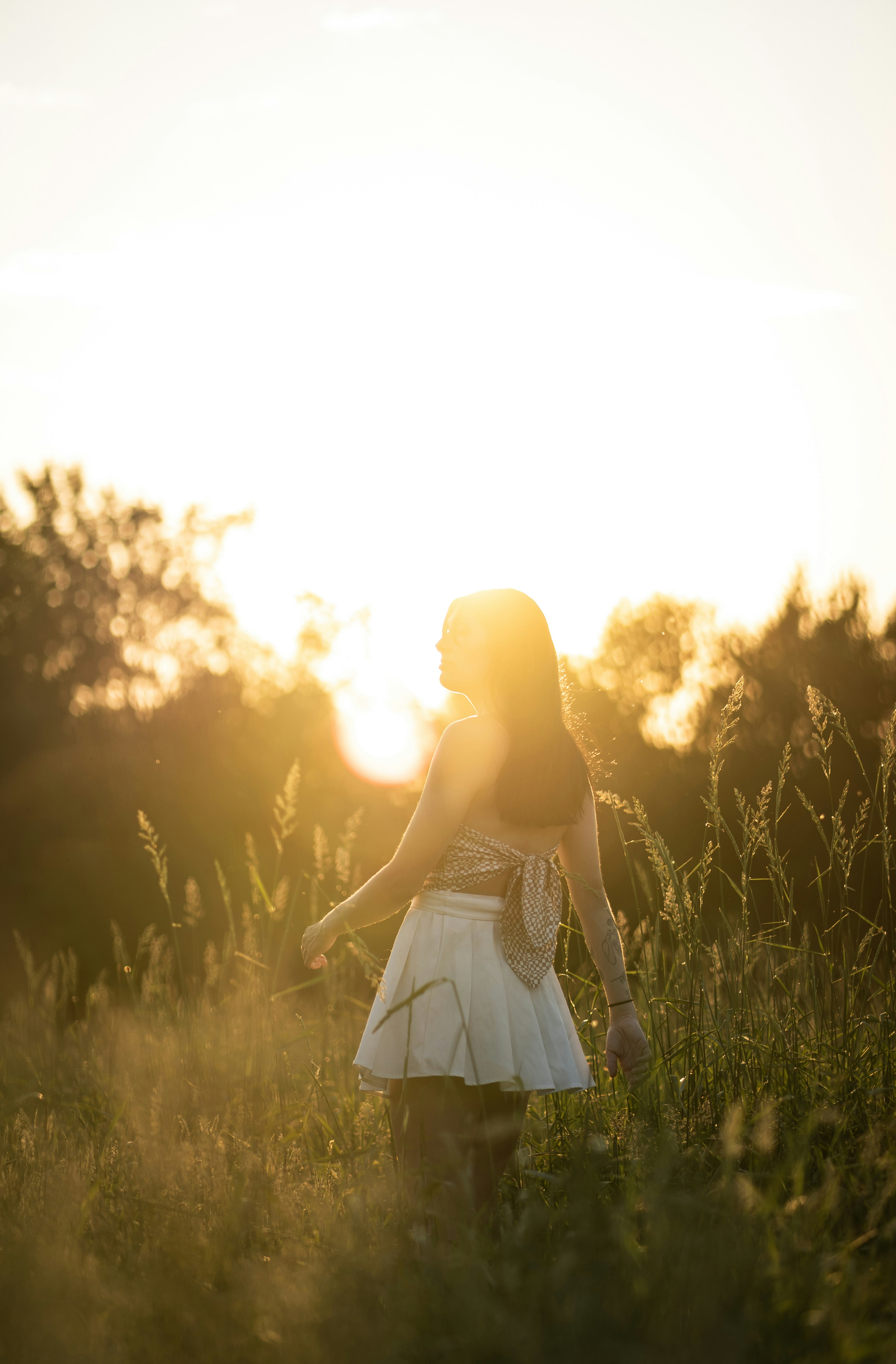 a woman standing in a field of tall grass