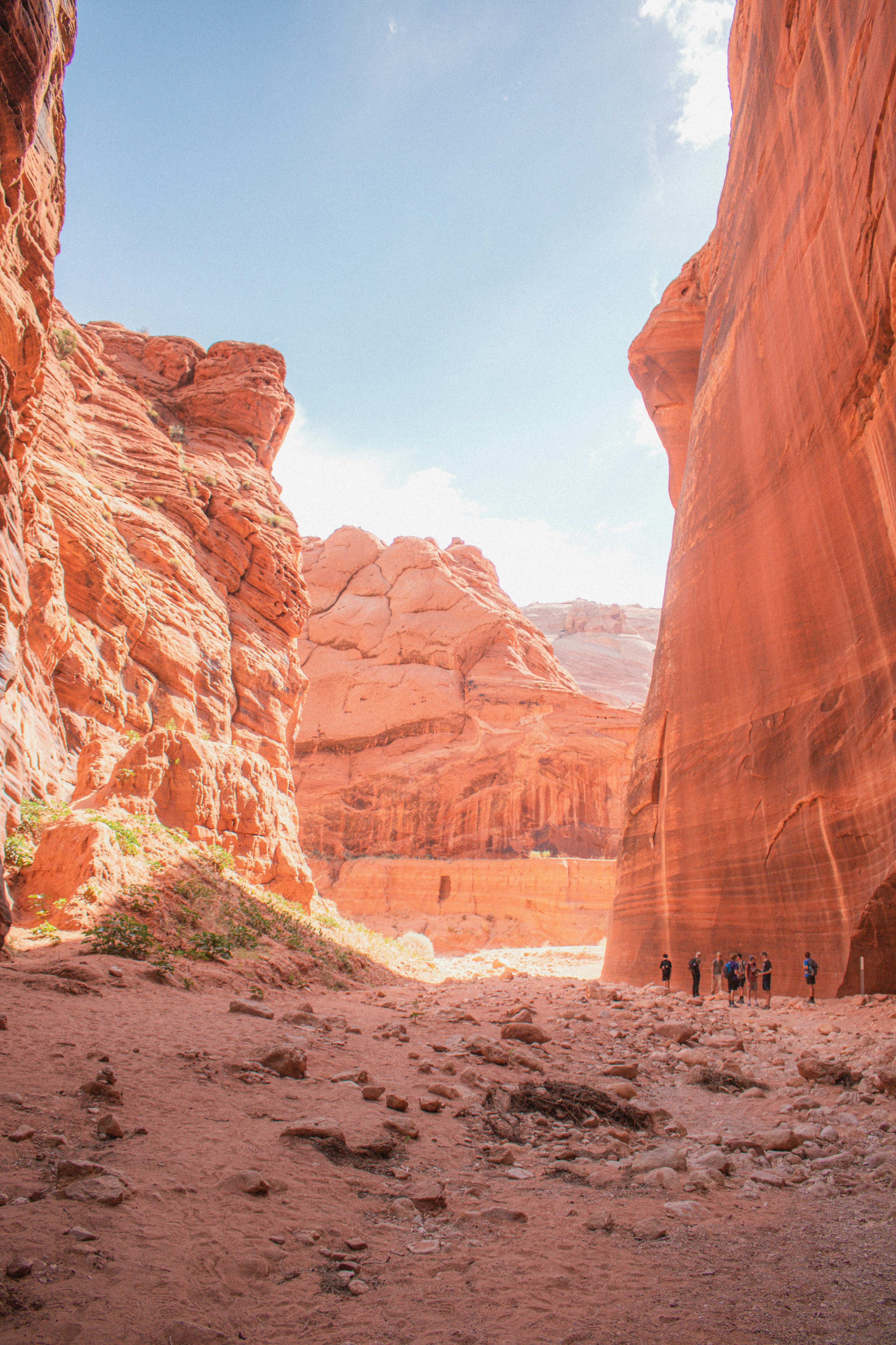 a group of people walking through a narrow canyon