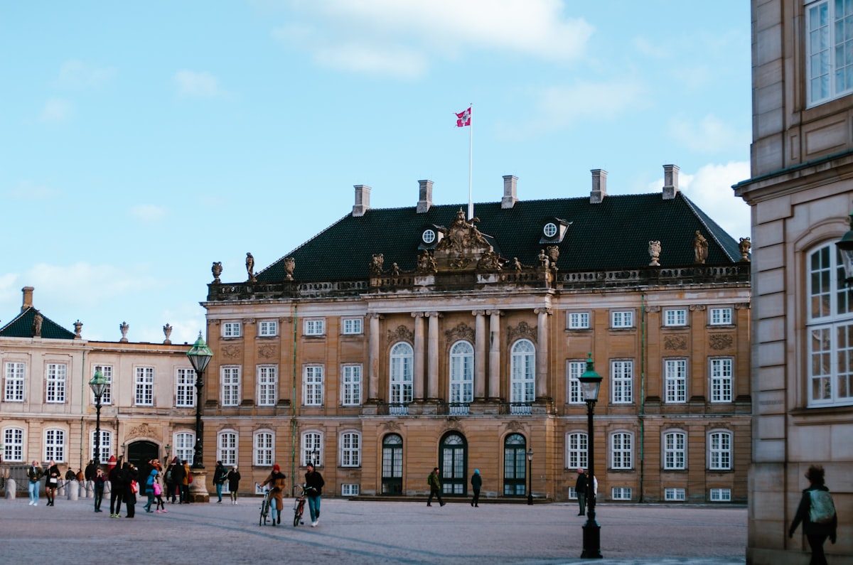 Copenhagen May — visitors walking around Amalienborg Palace square in spring sunshine