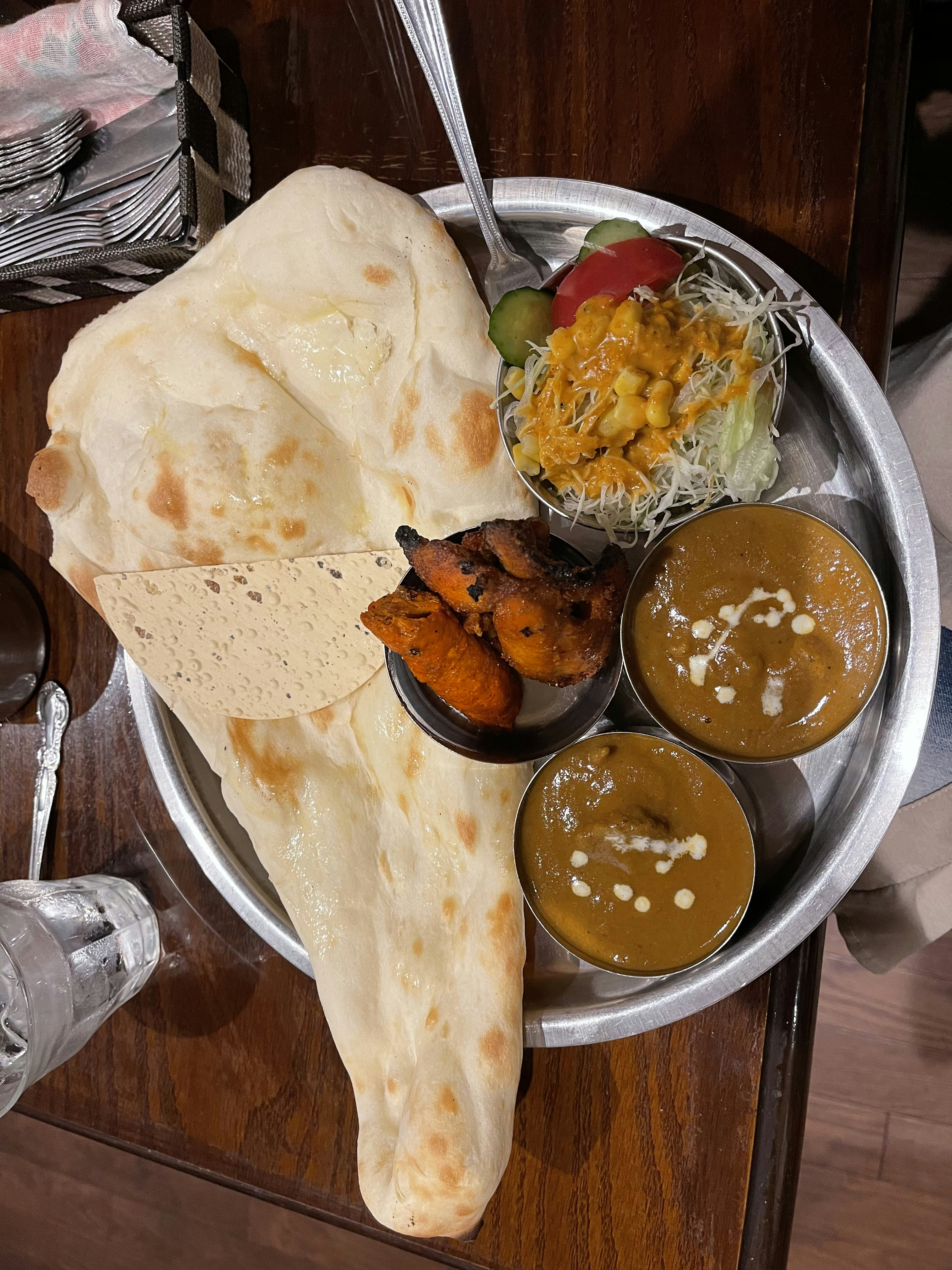 Freshly baked tandoori bread and rich North Indian curries in a traditional brass serving set