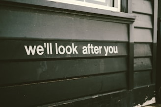 a sign on the side of a building that says we'll look after you