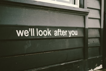 a sign on the side of a building that says we'll look after you