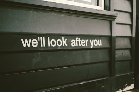 a sign on the side of a building that says we'll look after you