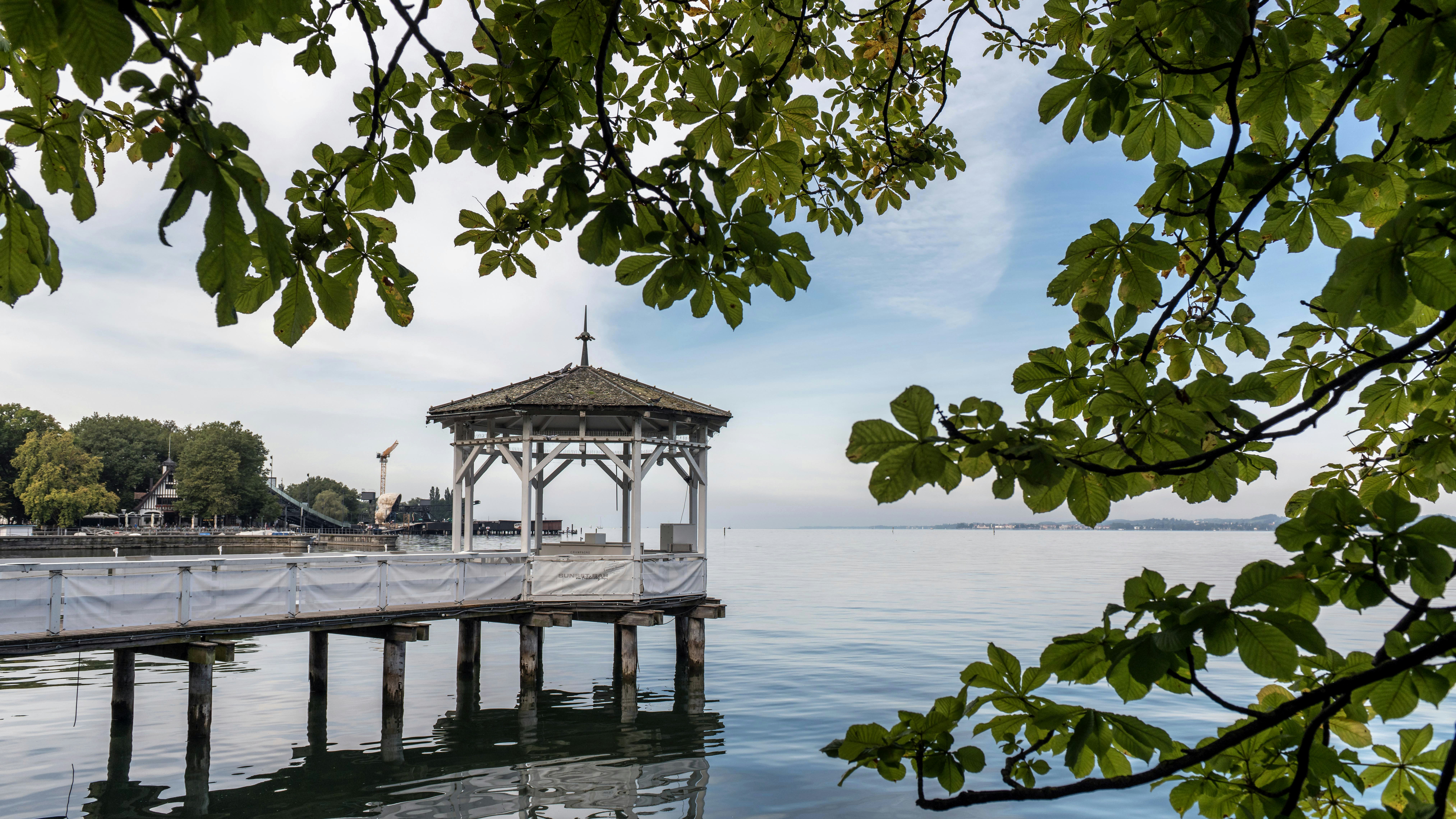 a gazebo sitting on top of a pier next to a body of water