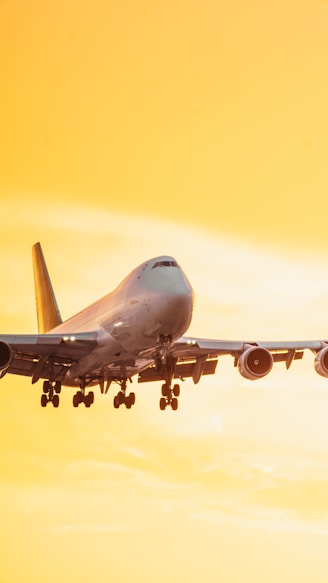 a large jetliner flying through a yellow sky