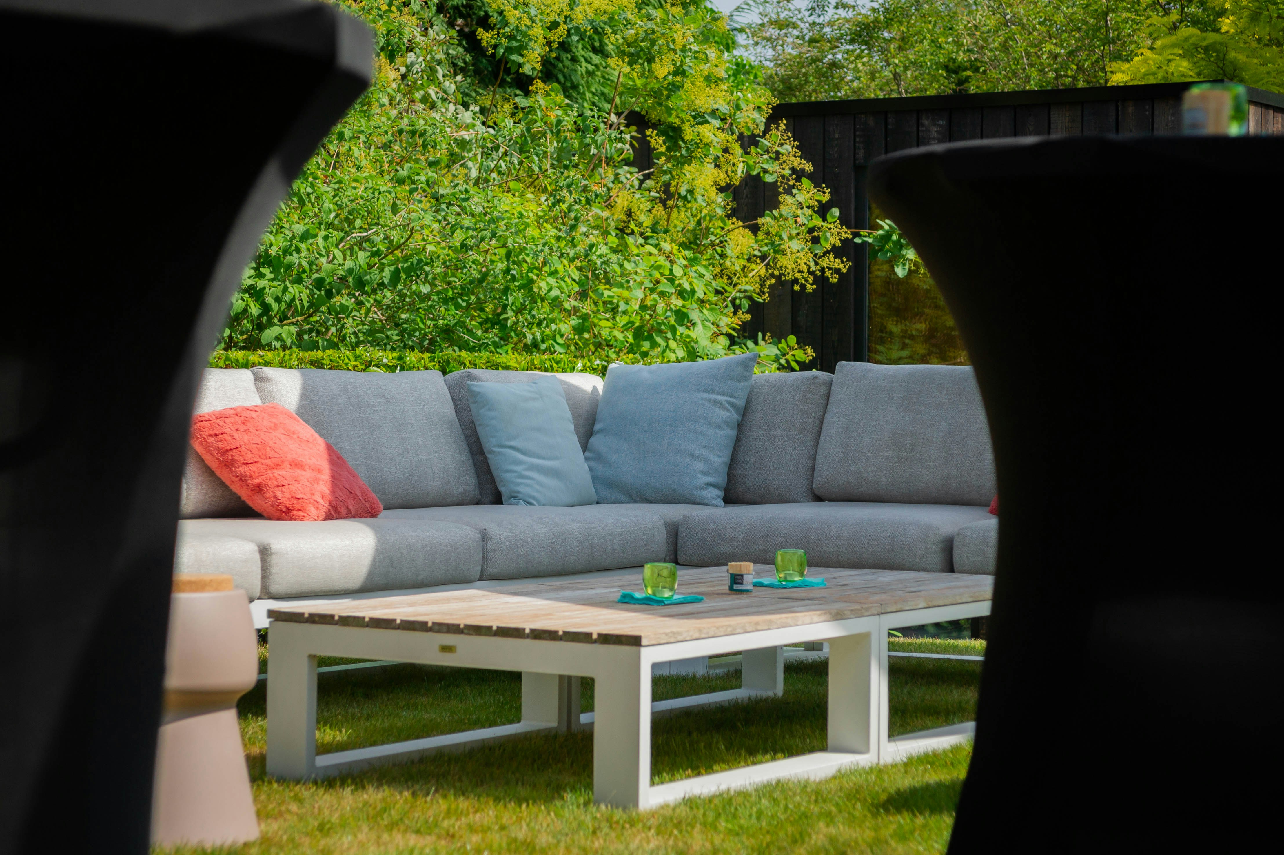 a couch sitting on top of a lush green field