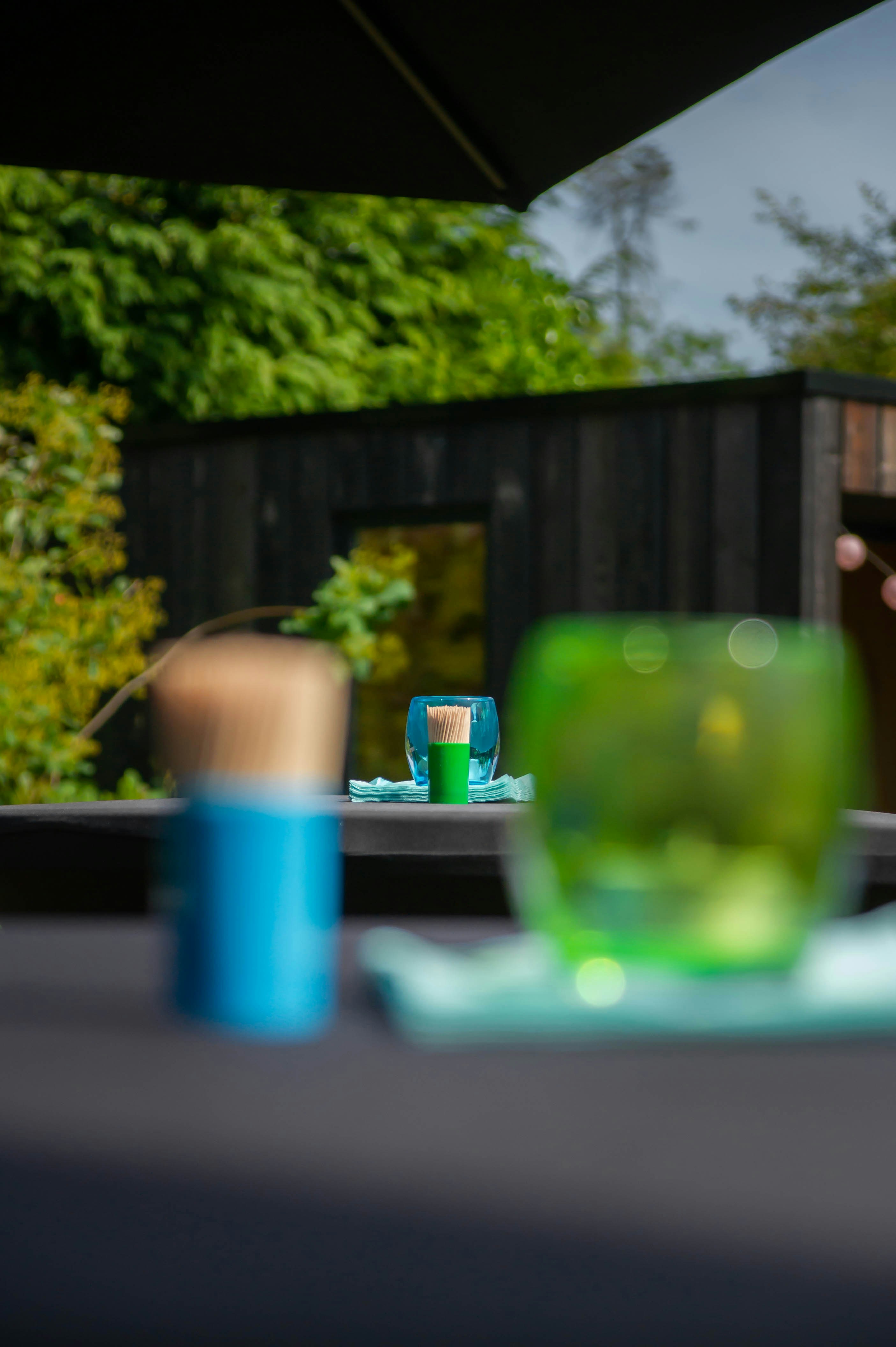 a green glass sitting on top of a table