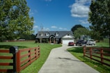a driveway leading to a house with a car parked in front of it