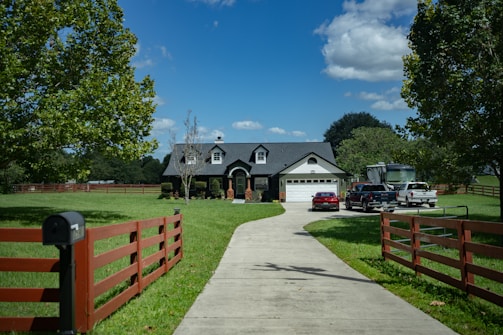 a driveway leading to a house with a car parked in front of it