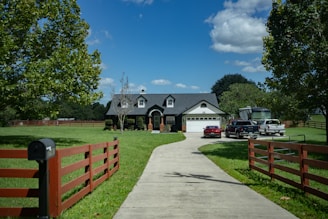 a driveway leading to a house with a car parked in front of it