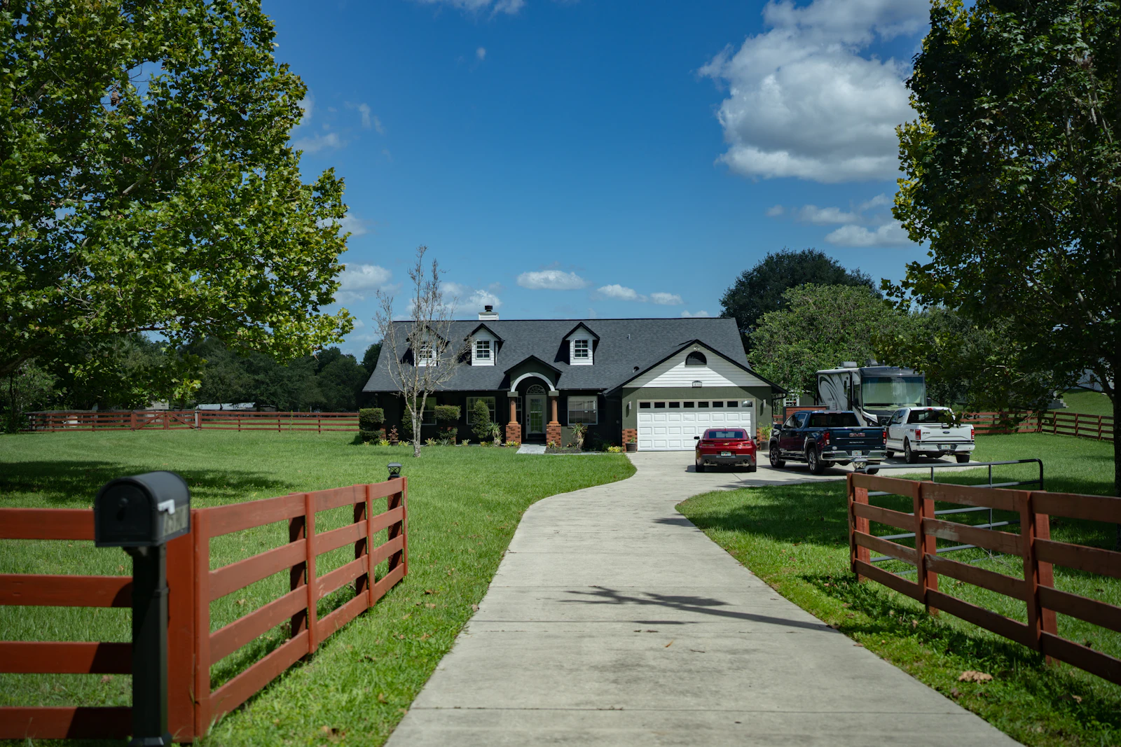 Cars in the driveway of a single-story house.