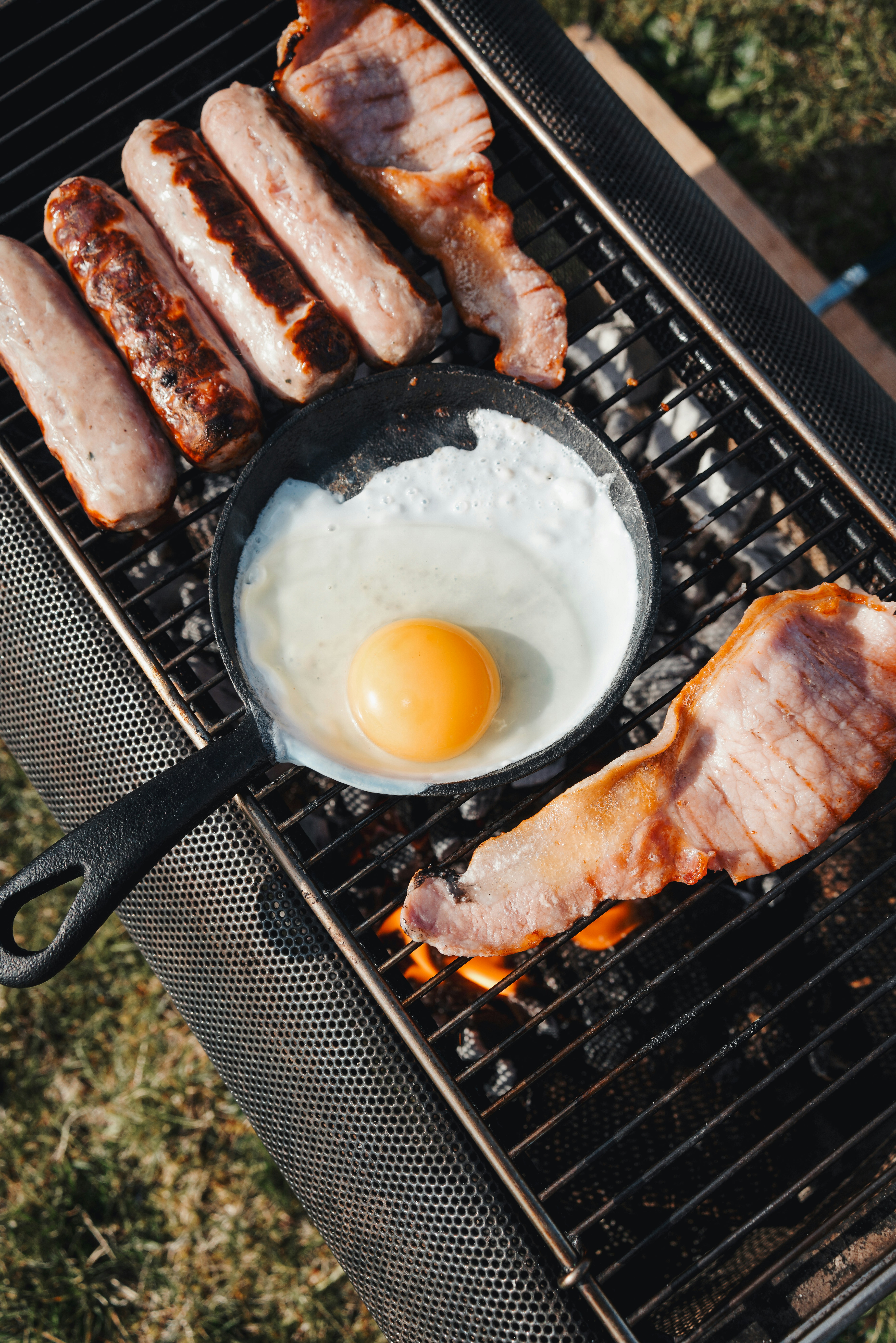 Sausage, egg, and bacon sizzle on a Biolite creating a mouthwatering breakfast amidst the Scottish Highlands.