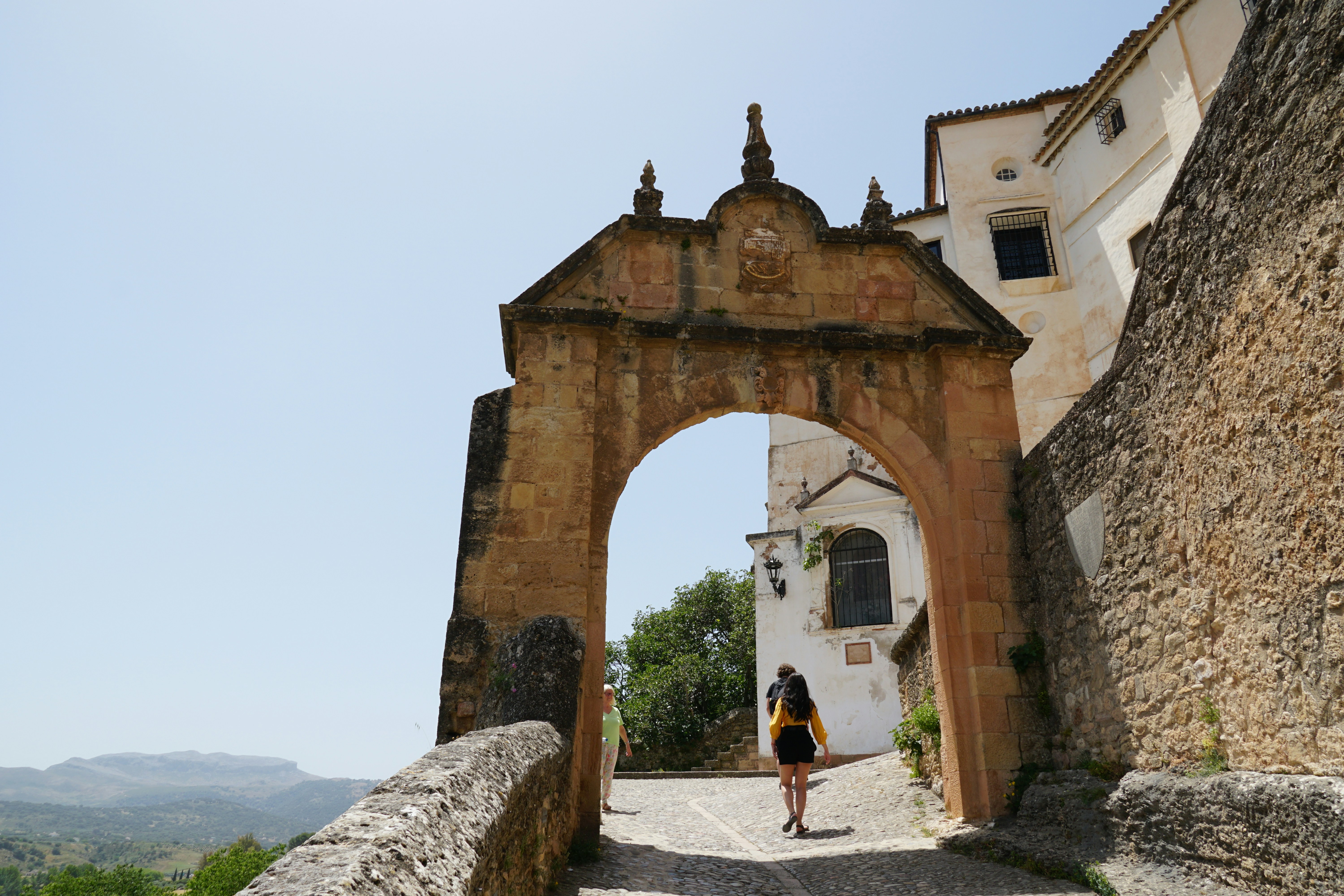 a woman is walking down a cobblestone road