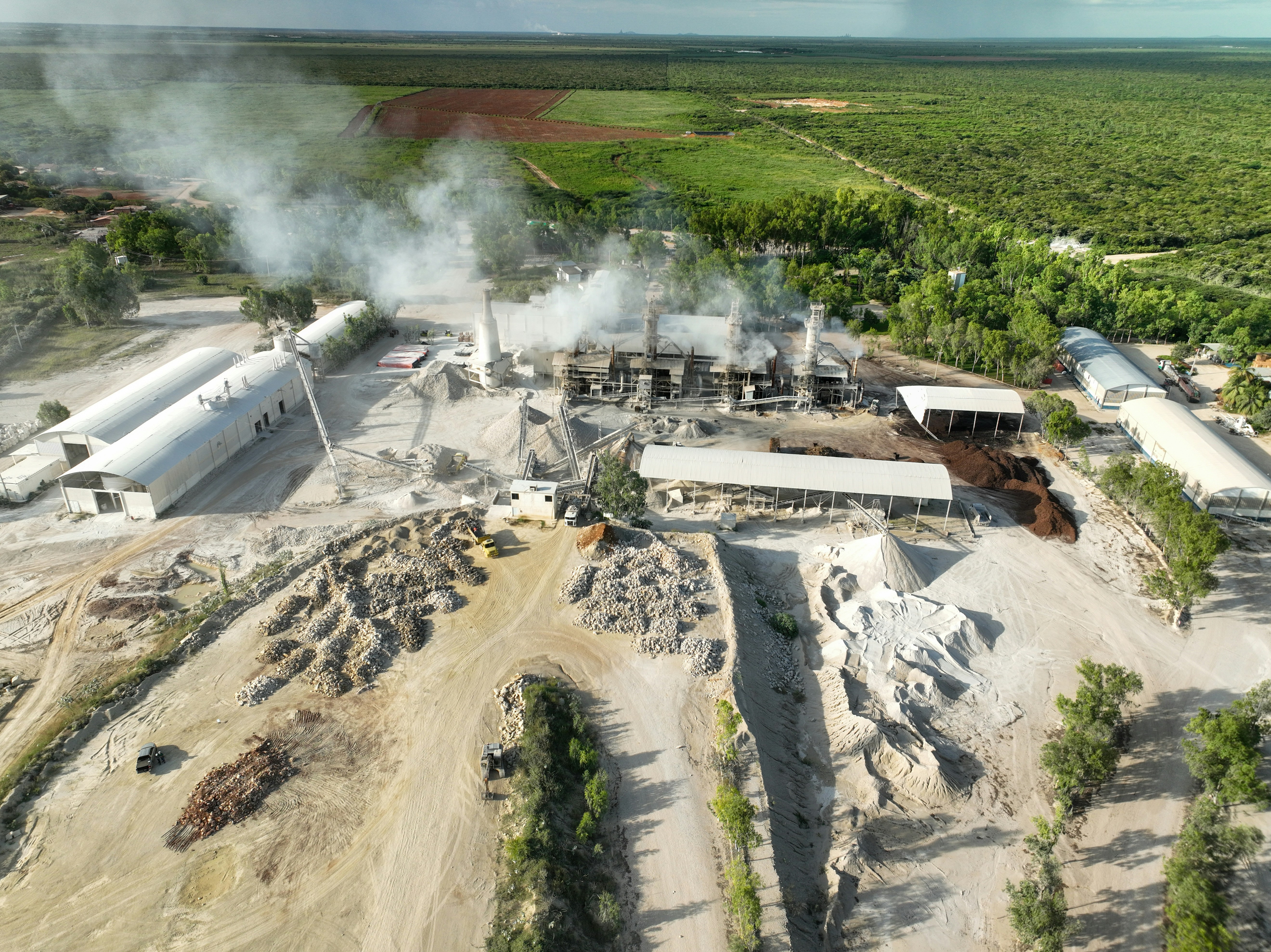 an aerial view of a factory with smoke coming out of it
