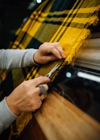 a person cutting a piece of fabric with a pair of scissors