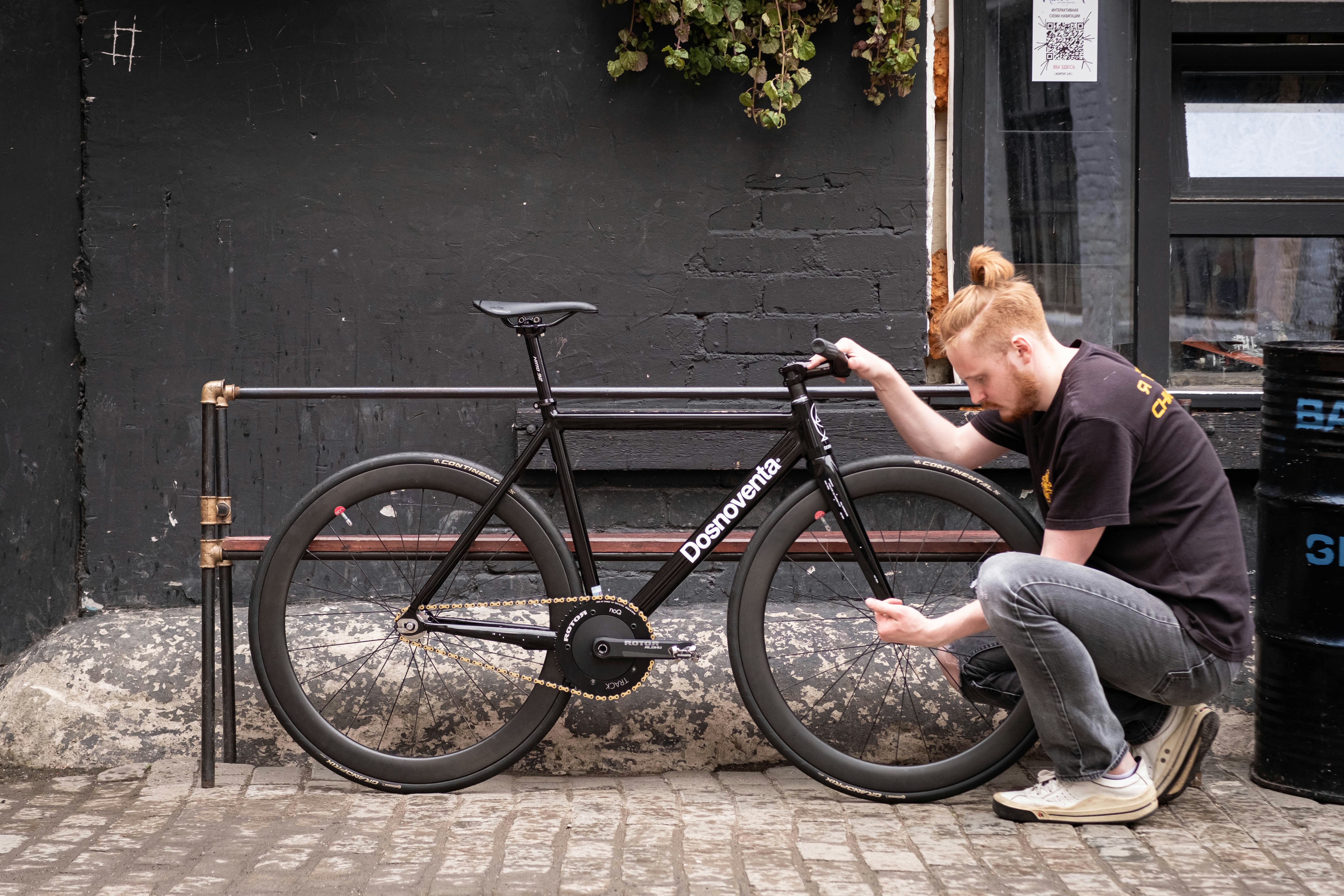 a man kneeling down next to a bike
