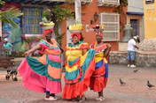 a group of women in colorful dresses standing next to each other