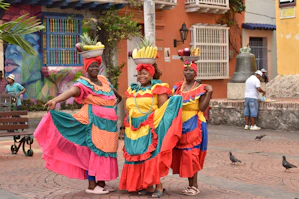 a group of women in colorful dresses standing next to each other